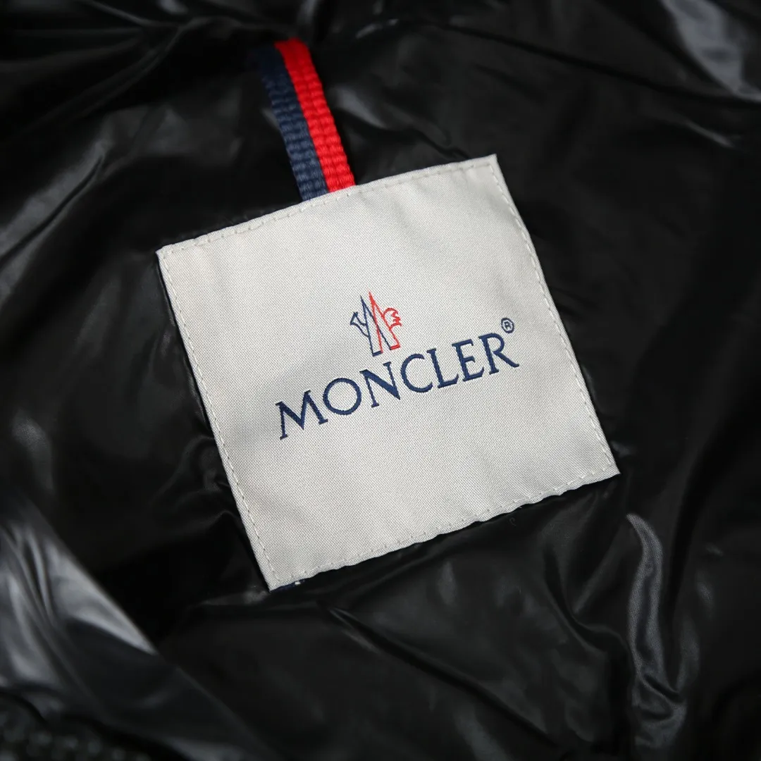 P900 MONCLER hooded brim quilted embroidered down jacket Fabric selection: The longue saison fabric is made of high-count polyamide fiber, which is known for its excellent tensile strength and lightness. Its good flexibility makes the fabric less prone to wrinkles and keeps it crisp and stylish for a long time. The tight weave effectively blocks the invasion of cold wind and locks in the warm air generated by the down layer. The high-density nylon surface forms a certain lotus leaf effect, making it difficult for small water droplets to penetrate, keeping the interior dry and effectively extending the service life of the down.  Lining selection: High-density lining fabric made of ultra-fine denier, 0.08mm thickness to avoid increasing the overall weight and making it smooth to wear. The high-density woven structure forms a wind resistance layer to protect the thermal efficiency of the thermal layer from loss. It can also withstand the expansion pressure of down and prevent deformation and damage after long-term use.  Technology: The quilted letter logo on the brim uses contour quilting technology. The stitching is routed along the edge of the set outline, and the filler is compressed inside the letter graphic, so that the logo is three-dimensional and convex, and the pattern is clear.  High-quality filling: It is filled with 90% selected white duck down, weighing 210g, ensuring fluffy rebound, lightness and warmth.  Accessories: one-to-one customized zipper pendant, one-to-one customized badge, one-to-one customized three-label SIZE: 1 2 3 4