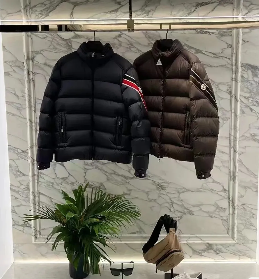 P920 2024N haute couture down moncler solayan men's three-color trimmed short down. Premium goose down filling. The most delicate, lightest and neatest fabric. Solayan men's short down is decorated with seasonal iconic stripe details, blending sportsmanship and timeless style. Solayan down is made of micro chic fabric and has a tough square shape design, highlighting Moncler's sporty spirit. This cropped style has tricolor stripes on the sleeves, a seasonal take on the brand's signature. Comes with a practical pull-out hood. Details · Made of micro chic nylon fabric · Micro chic nylon lining · Filled down · Pull-out hood · Zipper closure · Zipper pocket · Adjustable cuffs · Elastic drawstring hem · Tri-color trim on sleeves size: 1-5 Color: white, dark brown, black