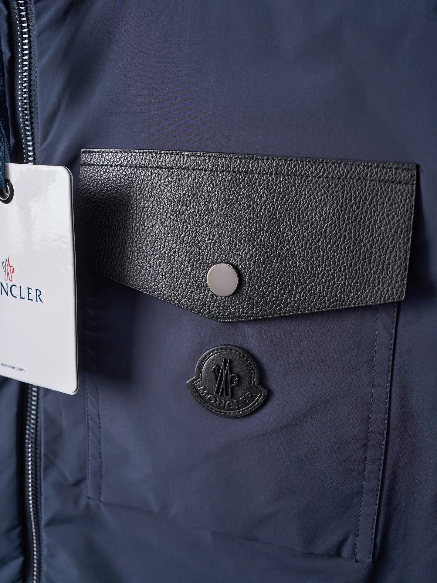 P860 Actual hanging auction] MONCLER/Maskled Leather Flap Pocket Logo Jacket Style Hooded Down Jacket [Ready Stock] 1 2 3 4 Made of 90 white duck down with a weight of 200g to ensure excellent thermal insulation performance. After strict screening and processing, the velvet is not easy to drill, ensuring durability. After selecting 100% polyester fiber and undergoing microfiberization treatment, the individual fibers become extremely fine, which greatly increases the fiber surface area, making the fabric soft, smooth, and close to natural fibers in touch. The high-density textile method makes the structure tight, thus giving it a certain degree of wrinkle resistance, windproof warmth and wear resistance.   The high-density lining is woven with ultra-fine denier, with a thickness of 0.08mm to avoid increasing the overall weight and making it smooth to wear. The high-density woven structure forms a wind resistance layer to protect the thermal efficiency of the thermal layer from loss. It can also withstand the expansion pressure of down and prevent deformation and damage after long-term use.  The leather flap pocket on the chest is matched with a pebbled leather flap + matte metal buckle, which is low-key yet exuding elegance. The hidden adjustment rope adds a sense of sophistication to your hands. The "ID card" is directly embedded on the black satin inner patch pocket! Silver snaps + red, white and blue webbing, low-key yet exuding a sense of luxury, both visually and tactilely smooth.