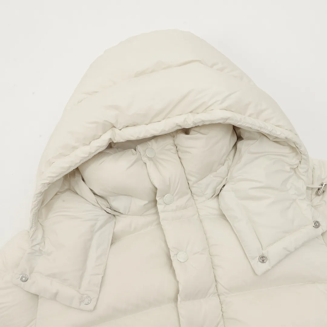 P1420 Moncler/Mask Maya matte down jacket This Vezere short down jacket is a basic warm item that highlights Moncler’s style characteristics. The Vezere down jacket is made from longue saison fabric, which is both lightweight and warm. This short down jacket features a hood that can be easily removed depending on the weather. The jacket's silhouette and sleeve patch pockets pay homage to the iconic Moncler Maya down jacket. ·Made of longue saison fabric·Nylon lé ger brillant lining filled with 90% goose down Detachable and adjustable hood with zipper and snap-button closure zippered pockets Patch pockets on sleeves·Adjustable cuffs·Drawstring hem Unisex Size: 1-5