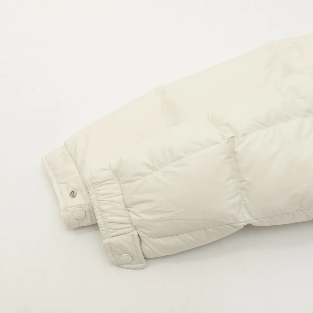 P1420 Moncler/Mask Maya matte down jacket This Vezere short down jacket is a basic warm item that highlights Moncler’s style characteristics. The Vezere down jacket is made from longue saison fabric, which is both lightweight and warm. This short down jacket features a hood that can be easily removed depending on the weather. The jacket's silhouette and sleeve patch pockets pay homage to the iconic Moncler Maya down jacket. ·Made of longue saison fabric·Nylon lé ger brillant lining filled with 90% goose down Detachable and adjustable hood with zipper and snap-button closure zippered pockets Patch pockets on sleeves·Adjustable cuffs·Drawstring hem Unisex Size: 1-5
