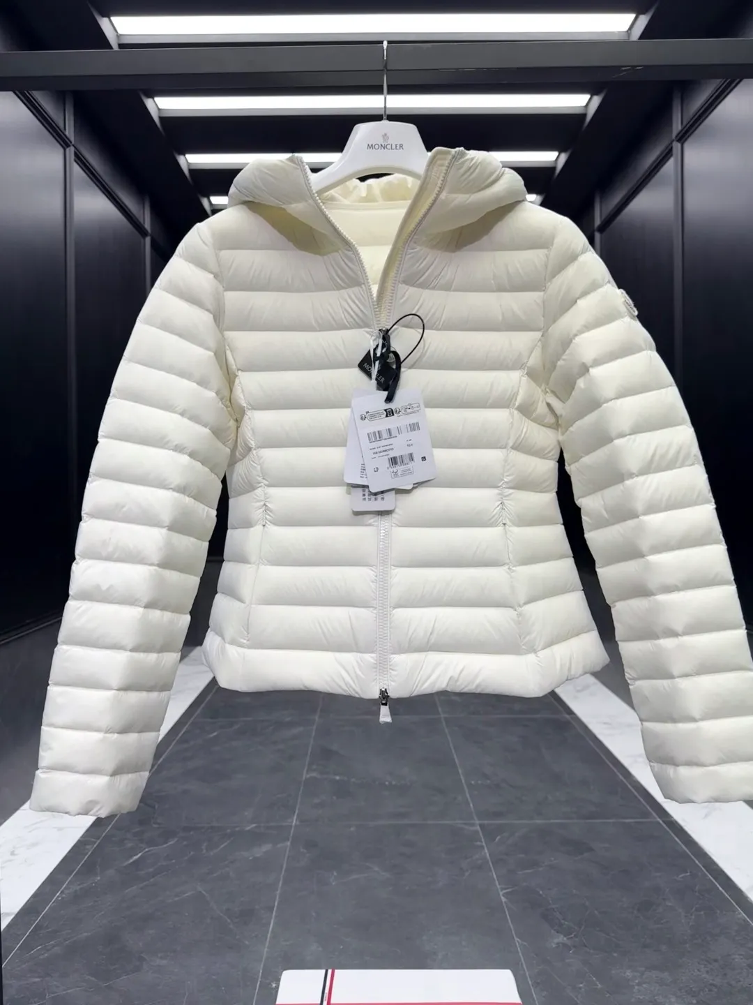 P700 Premium down⬆️Moncler. New Ige hooded short down jacket for women. Ige hooded short down jacket. The Ige down jacket is made of longue saison fabric and is suitable for mild weather. This nylon fabric is warm without being bulky. Designed in a cropped silhouette, it features a classic hooded silhouette and a cinched waist for a smooth, feminine look. It is recommended to choose one size up.  • Made of longuesaison fabric • Longuesaison lining • Filled with down • Hood • Zipper closure • Zippered pocket Size: 1-4 Ivory/Black D00700