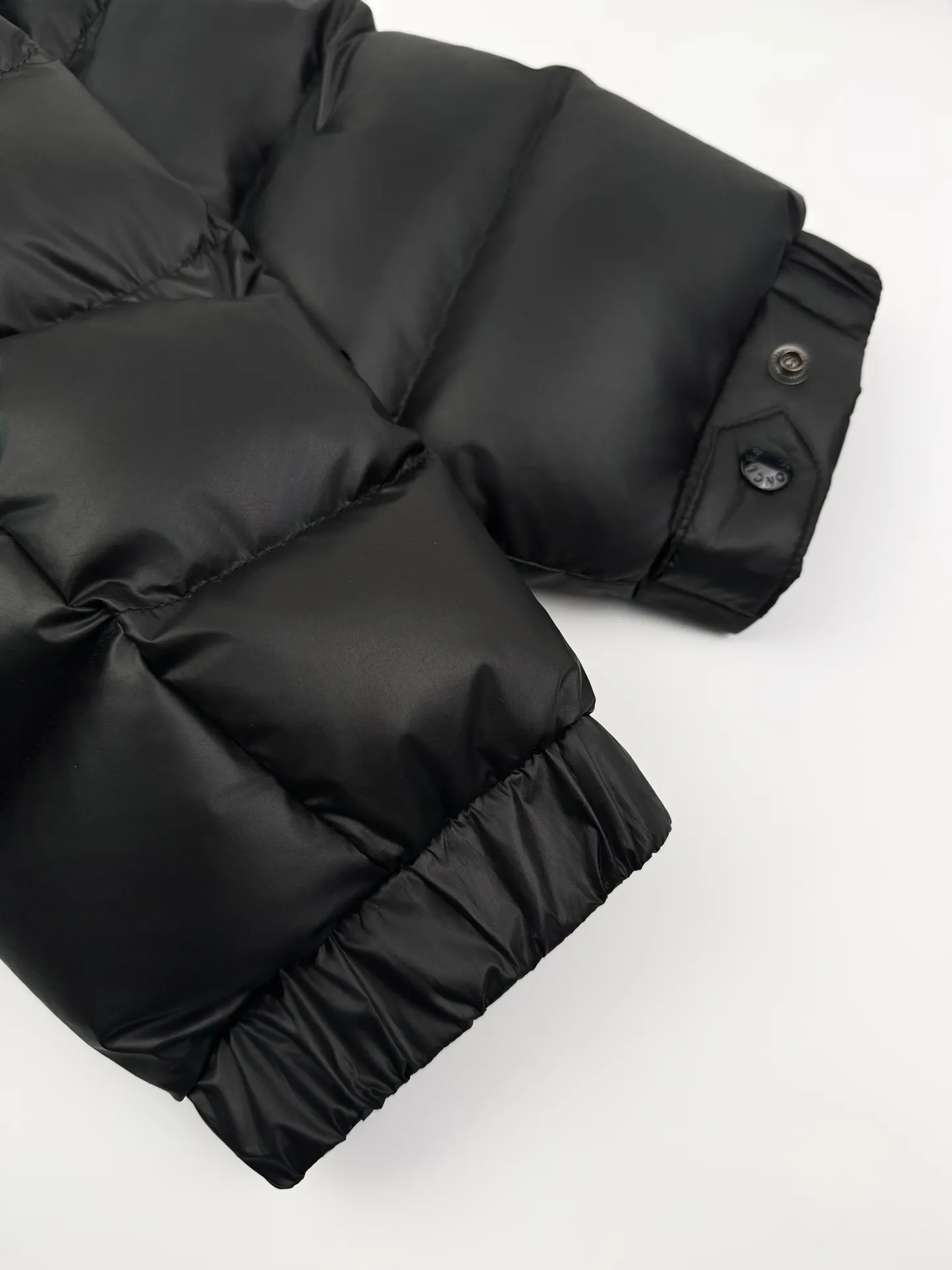 P1260 Moncler Batman Logo Down Jacket Customized black premium carbon black coated windbreaker fabric Customized Korean trendy velvet knitted fabric Made of 400D calendered bile fabric National standard 95 white goose down (welcome to test) Full of down content Warmth and light fluffy Craftsmanship to create a joint series Decorated with the Batman logo on the front Inspired by the famous superhero High degree of recognition The iconic Moncler embroidered logo is present on the sleeves It highlights the brand style and pays tribute to the classics. It is also an interpretation of modern fashion. It tightly locks in body temperature and enjoys warmth and comfort. It becomes the most intimate companion in winter. Process 1: Computer laser burning and cutting. It uses a high-energy laser beam to instantly melt the fabric fibers at high temperature. Precise cutting and engraving on the fabric according to the original pattern. The edges are flat to achieve seamless splicing. It effectively prevents the penetration of cold wind and improves the thermal insulation performance of the down jacket. Process 2: Computer mechanical down filling. Priority is given to making the inner liner pattern to determine the down filling area according to the original three-dimensional effect to determine the gram weight of down per square meter, thereby calculating the filling amount of each cut piece. The computer down filling machine uses a digital weighing unit to achieve stable measurement. Process 3: Computer template machine line running process. The line running process of the computer template machine shows extremely high neatness and smoothness. The craftsman accurately controls the size during the operation to ensure that each row line meets the design requirements. The lines of the entire template are smooth and unified, clean and beautiful. Paving: Customized 1:1 Moncler snap button Customized 1:1 Moncler zipper Customized 1:1 Moncler adjustment buckle Customized 1:1 Moncler pendant Customized 1:1 Moncler machine eye Customized 1:1 Moncler embroidered logo Customized 1:1 Moncler trademark Function: Detachable and adjustable hood. Match as you like Size: 1 code 2 codes 3 codes 4 codes 5 codes 6 codes