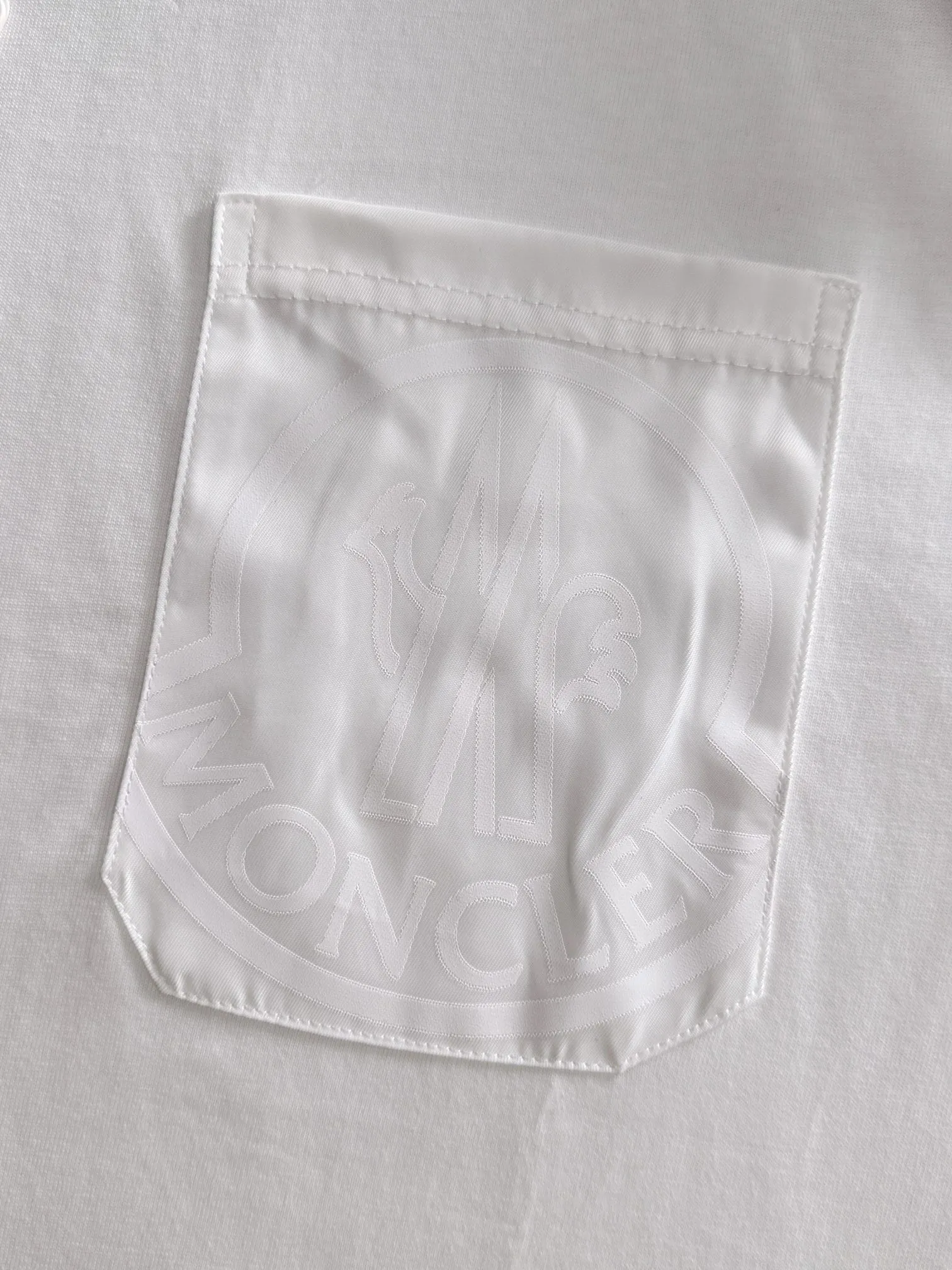 P160 Moncler 2025 new model Woven pocket splicing Hollow embroidered letter logo Uniform short-sleeved T-shirt for men and women ·Customized 260g 100% double yarn pure cotton fabric ·Dyeing 32 counts double-strand thread ·Collar label, hangtag, main mark and three labels complete Color: White Size: XS S M L