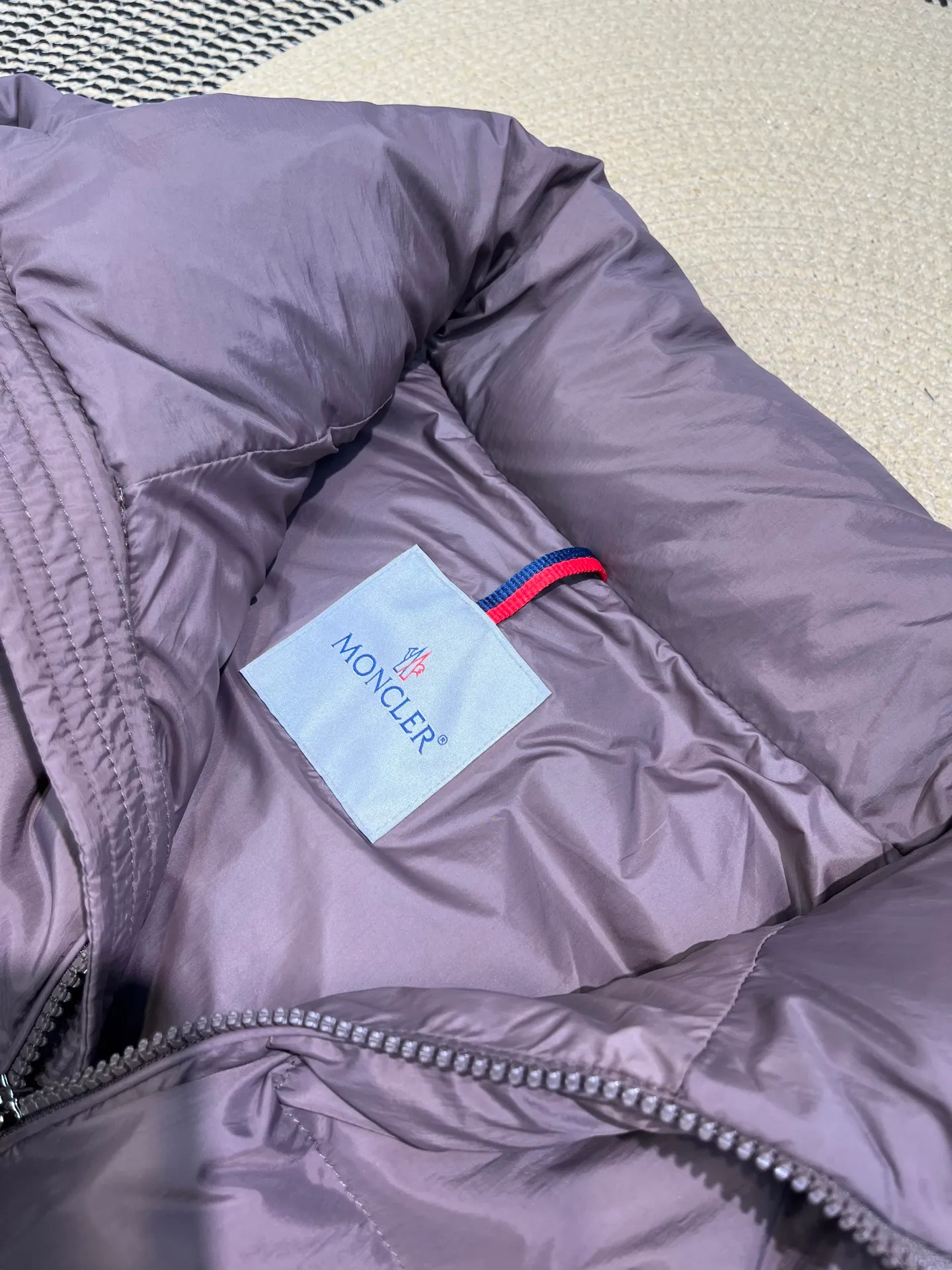 P840 Moncler Solayan men's tri-color trim short down jacket. Filled with premium goose down. The finest, lightest and neatest fabric. Solayan men's short down jacket is decorated with the season's signature stripe details, blending sporty spirit with timeless style. The Solayan down jacket is made of micro chic fabric and has a tough square shape design, highlighting Moncler's sporty spirit. This cropped down jacket features tricolor stripes on the sleeves, a seasonal take on the brand's signature. Comes with a practical pull-out hood. Details •Made from micro chic nylon fabric •Micro chic nylon lining •Down filled •Pull-out hood •Zip closure •Zip pockets •Adjustable cuffs •Elastic drawstring hem •Tri-color trim on sleeves Size: 1-5 Color: White Dark Brown Black