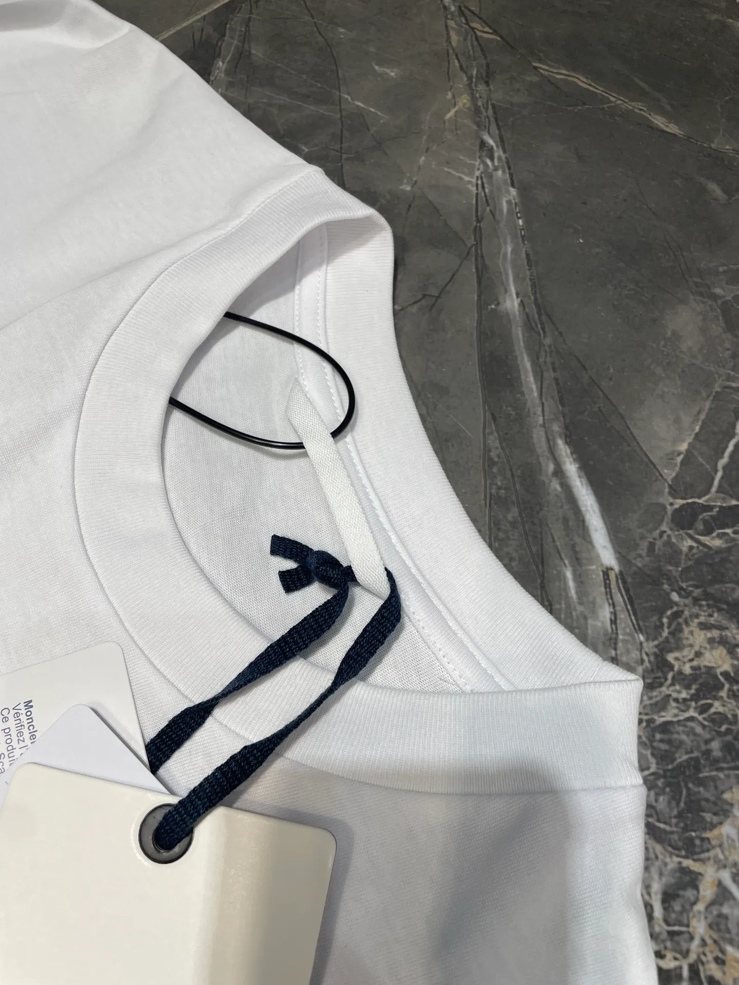P200 MONCLER 🌟Mask foam printed armband short sleeves. Fabric: Made of 32 pairs of yarn, threaded with 1*1 Solona. Craftsmanship: The chest logo adopts foam printing technology, and the original customized stencil is used. Every detail and color is highly restored to the original version 1:1. Accessories: The armband is made of cashmere composite material, with the brand logo embroidered on the surface. The detailed positions of auxiliary materials are restored according to 1:1 positioning. Accessories: Customized 1:1 washed trademark Accessories: Customized 1:1 composite armband Process: Customized 1:1 foam printing Size: S-M-L-XL Color: Black-White
