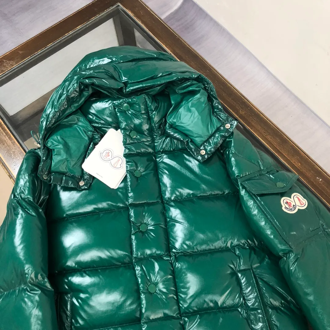 P800 Moncler Maya 70 Short Down Jacket Forest Green The iconic men's Moncler Maya 70 down jacket is highly recognizable and specially designed to celebrate the brand's 70th anniversary. The Moncler Maya down jacket has been reinterpreted specifically to celebrate Moncler's 70th anniversary, and the iconic silhouette has been refreshed in new colors. A classic example of the brand's DNA, it's made from shiny lacquered nylon and embellished with signature rectangular quilting. A classic, cropped design that spans seasons and fashions, the removable hood features a statement silhouette, removable hood and adjustable hem. The sleeves are decorated with the brand's signature classic patch pockets and a patchwork logo designed to celebrate the 70th anniversary. Color: black, ivory white, basalt gray, purple, cabin brown, forest green, code number: 1-2-3-4-5 (M～3xl)