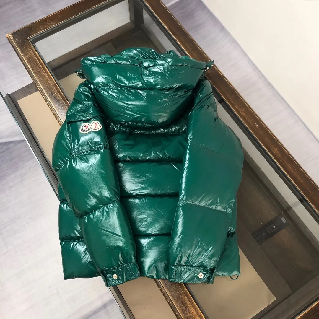 P800 Moncler Maya 70 Short Down Jacket Forest Green The iconic men's Moncler Maya 70 down jacket is highly recognizable and specially designed to celebrate the brand's 70th anniversary. The Moncler Maya down jacket has been reinterpreted specifically to celebrate Moncler's 70th anniversary, and the iconic silhouette has been refreshed in new colors. A classic example of the brand's DNA, it's made from shiny lacquered nylon and embellished with signature rectangular quilting. A classic, cropped design that spans seasons and fashions, the removable hood features a statement silhouette, removable hood and adjustable hem. The sleeves are decorated with the brand's signature classic patch pockets and a patchwork logo designed to celebrate the 70th anniversary. Color: black, ivory white, basalt gray, purple, cabin brown, forest green, code number: 1-2-3-4-5 (M～3xl)
