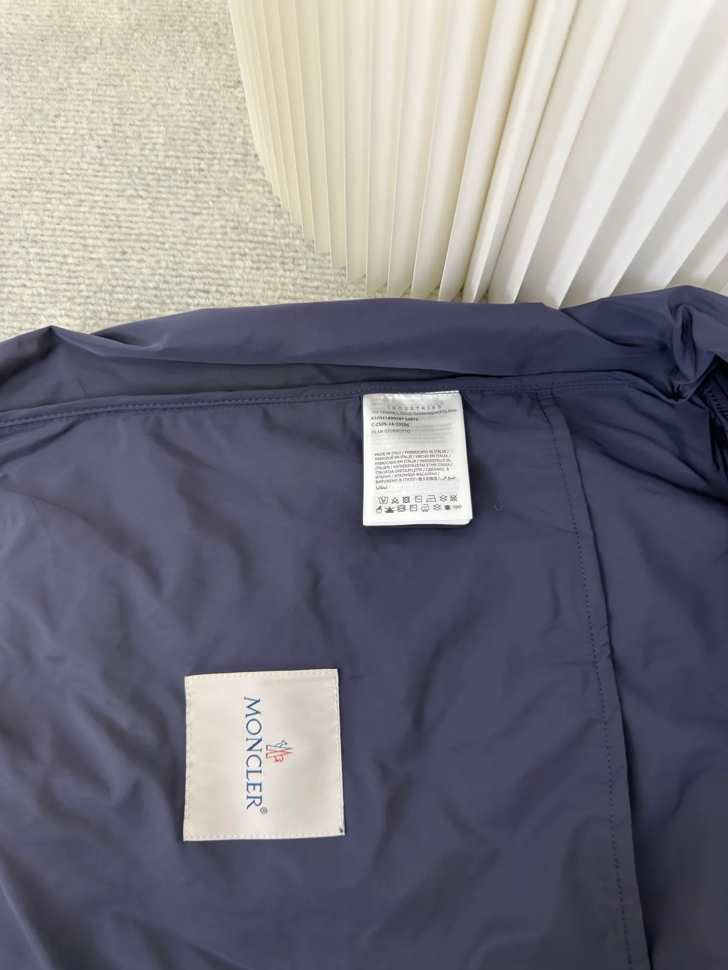 P570 MONCLER lightweight jacket with web trim at the mouth is made of 100% polyester fiber to create a tough protective outer layer. It is famous for its excellent tear resistance and wear resistance. It can quickly return to flatness during wearing and maintain the crisp and stylish appearance of the clothing for a long time. At the same time, it is not easy to deform after being washed for a long time.  Decorative edging in two different colors has been added to the center section of the sleeves. This design element not only adds visual highlights to clothing, making it more fashionable and unique. The webbing is precisely positioned along the cuffs to the seam of the collar and hat to ensure symmetry and overall smoothness. Before actual sewing, use very fine basting stitches for pre-fixing. This step is crucial to prevent the webbing from slipping, twisting, or wrinkling during sewing and ensuring that the final stitch is straight and perfect. Size 1 2 3 4