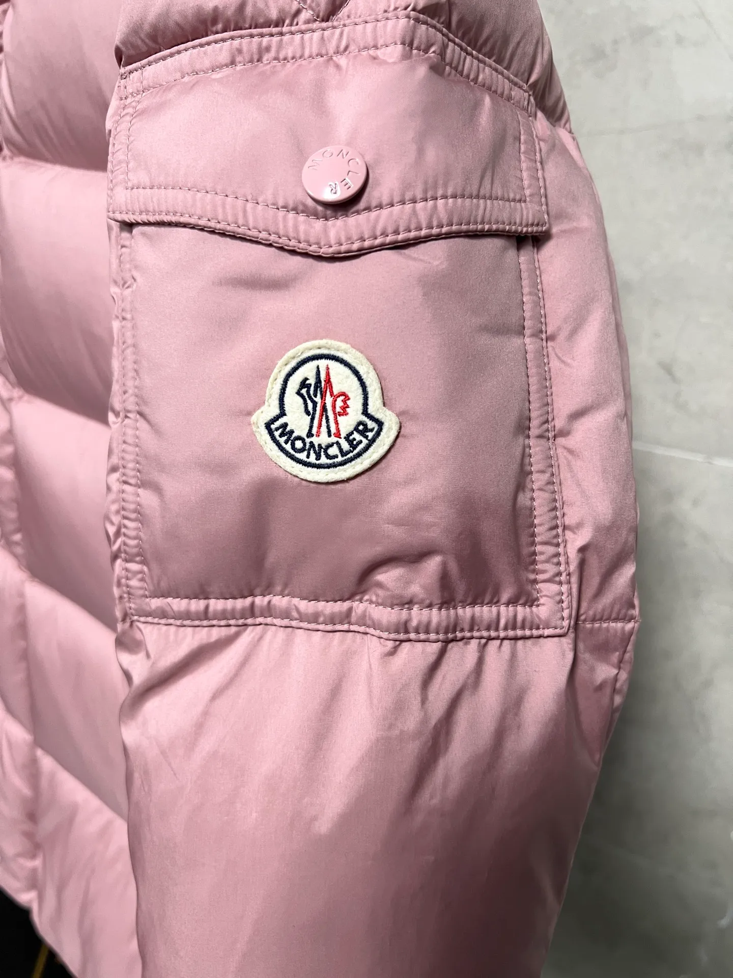 P800 Moncler matte Maya short down jacket. This short parka down jacket is made of longueSaion fabric. The garment is full of functional details to ensure warmth and care. Features removable hood, zip pockets, adjustable cuffs, and snap-zip flap fly. Logo embellished sleeves. It adds a unique touch to the overall shape and significantly improves the protective performance. Color: Black White Pink Pearl White Size: 12345