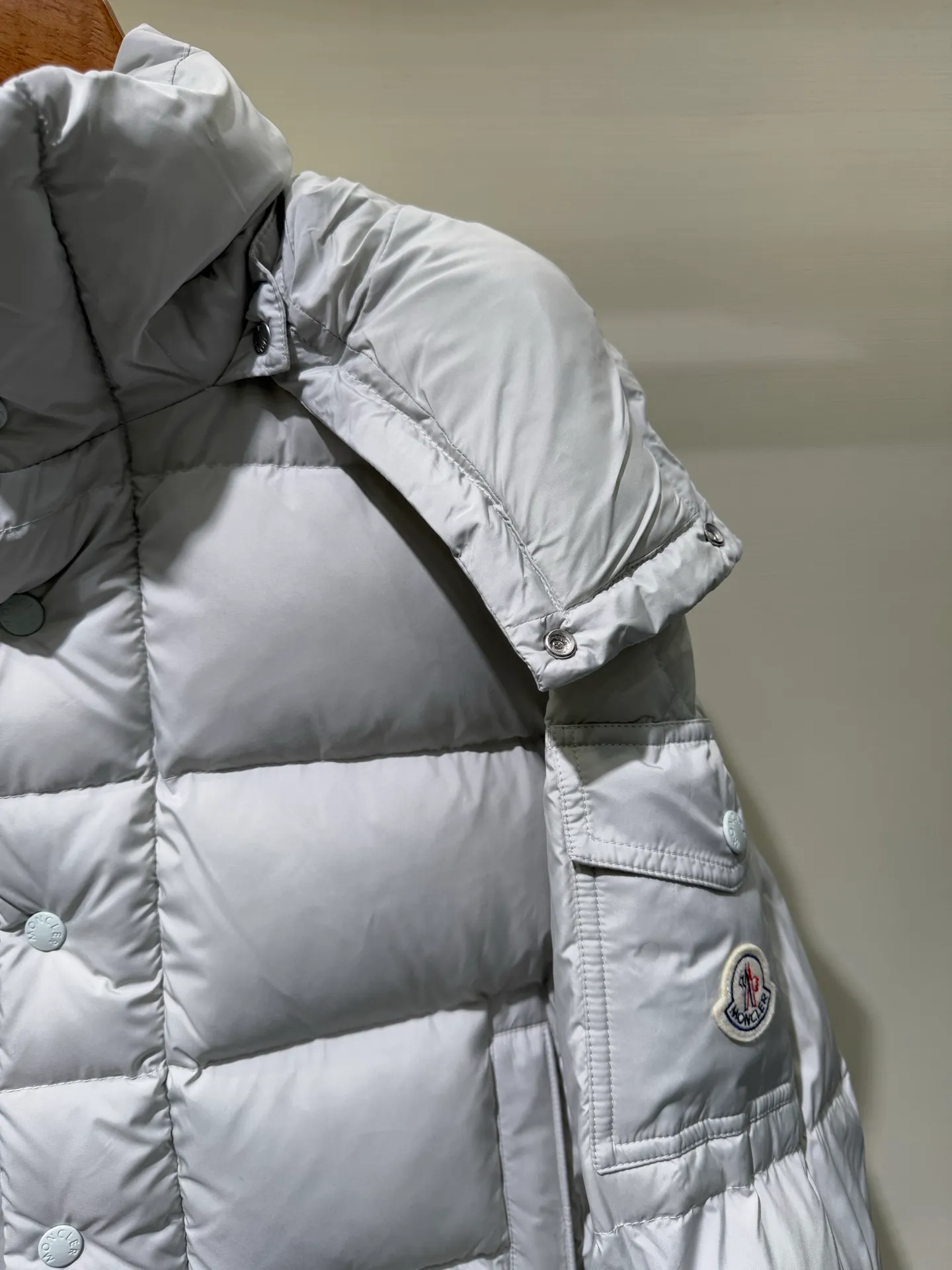 P1080 Moncler Maya Meng Maya Pearl Gray and White Short Down Jacket The Moncler Maya down jacket is made of matte nylon with iconic rectangular quilting, which is a model of Moncler style. A classic cropped design that transcends seasons and styles, it features a statement silhouette, removable hood and adjustable hem. The sleeves are embellished with classic patch pockets, showcasing the brand's signature style.  Fabric: 100% nylon, 90% white duck down Craftsmanship: Made of matte nylon, lacquered nylon lining filled with down, rectangular quilting, detachable hood with snap buttons that can be adjusted by drawstring, two-way zip fly, external and internal zipper pockets, adjustable elastic cuffs with snap buttons, hood with drawstring, sleeves with flap patch pockets, sleeves decorated with Moncler felt trademark. (Supports NFC function) Size: 01234 3543050