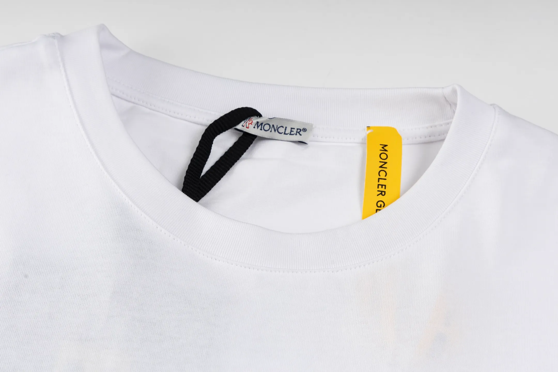 P230 exclusive supply] Moncler Hiroshi Fujiwara co-branded short-sleeve (white) is made of double-ply cotton plain fabric. The warp and weft yarns are interwoven one up and down to form a uniform grid-like texture, with a tight but light structure. Cotton fiber has natural breathability and skin-friendly properties. Combined with the pore structure of plain weave, it is suitable for daily perspiration needs and has good wearing comfort. The yarn has many intertwining points, which strengthens the tear resistance and can maintain its shape after multiple washings. Four high-saturation patterns are presented on the fabric through glue printing. The scraper pressure is even and the scraping is performed in three steps to ensure that the glue is fully penetrated and covered. After curing at high temperature, the pigment is firmly bonded to the cotton fiber. The ink-absorbing and penetrating properties of the cotton fiber make the pattern less likely to fall off due to friction. By actively interfering with the shrinkage potential of cotton fibers, the fabric is able to transition from changeable to stable, improving dimensional stability while being less prone to deformation and wrinkles. Size:S-M-L-XL