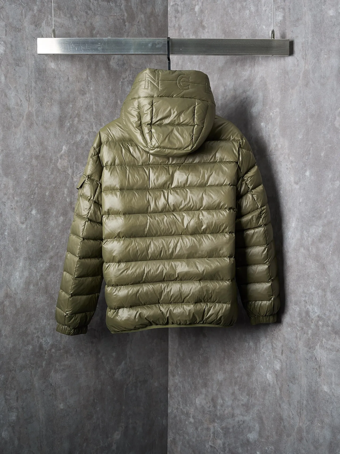 P900 Actual hanging auction] MONCLER/Maskled brim quilted embroidered pocket logo hooded down jacket [Ready stock] 1 2 3 4 Filled with 90 selected white duck down, weighing 210g, ensuring fast fluffy rebound, lightness and warmth.  The longue saison fabric made of high-count polyamide fiber is famous for its excellent tensile strength and lightness. Its good flexibility makes the fabric less prone to wrinkles and keeps it crisp and stylish for a long time. The tight weave effectively blocks the invasion of cold wind and locks in the warm air generated by the down layer. The high-density nylon surface forms a certain lotus leaf effect, making it difficult for small water droplets to penetrate, keeping the interior dry and effectively extending the service life of the down.  The high-density lining is woven with ultra-fine denier, with a thickness of 0.08mm to avoid increasing the overall weight and making it smooth to wear. The high-density woven structure forms a wind resistance layer to protect the thermal efficiency of the thermal layer from loss. It can also withstand the expansion pressure of down and prevent deformation and damage after long-term use.  The quilted letter logo on the brim uses contour quilting technology. The stitches are routed along the edge of the set outline, and the filler is compressed inside the letter graphic, so that the logo is three-dimensional and the pattern is clear.