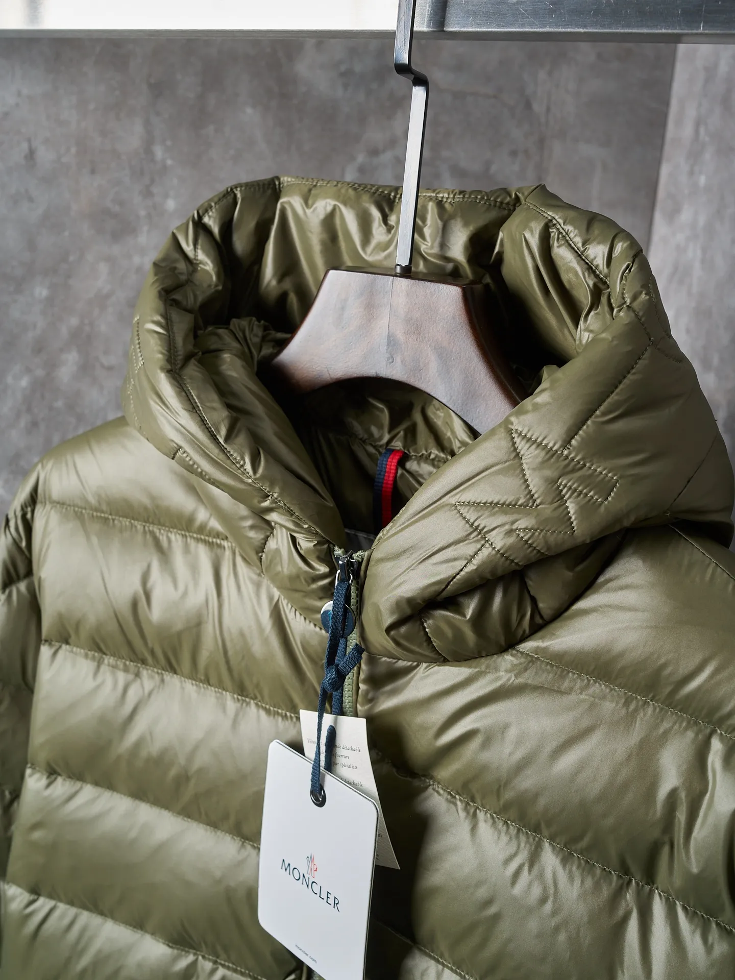 P900 Actual hanging auction] MONCLER/Maskled brim quilted embroidered pocket logo hooded down jacket [Ready stock] 1 2 3 4 Filled with 90 selected white duck down, weighing 210g, ensuring fast fluffy rebound, lightness and warmth.  The longue saison fabric made of high-count polyamide fiber is famous for its excellent tensile strength and lightness. Its good flexibility makes the fabric less prone to wrinkles and keeps it crisp and stylish for a long time. The tight weave effectively blocks the invasion of cold wind and locks in the warm air generated by the down layer. The high-density nylon surface forms a certain lotus leaf effect, making it difficult for small water droplets to penetrate, keeping the interior dry and effectively extending the service life of the down.  The high-density lining is woven with ultra-fine denier, with a thickness of 0.08mm to avoid increasing the overall weight and making it smooth to wear. The high-density woven structure forms a wind resistance layer to protect the thermal efficiency of the thermal layer from loss. It can also withstand the expansion pressure of down and prevent deformation and damage after long-term use.  The quilted letter logo on the brim uses contour quilting technology. The stitches are routed along the edge of the set outline, and the filler is compressed inside the letter graphic, so that the logo is three-dimensional and the pattern is clear.