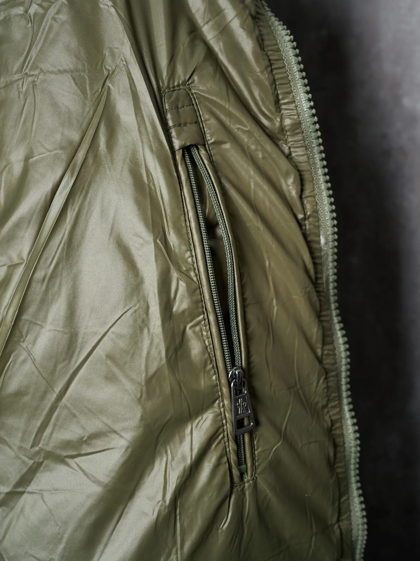 P900 Actual hanging auction] MONCLER/Maskled brim quilted embroidered pocket logo hooded down jacket [Ready stock] 1 2 3 4 Filled with 90 selected white duck down, weighing 210g, ensuring fast fluffy rebound, lightness and warmth.  The longue saison fabric made of high-count polyamide fiber is famous for its excellent tensile strength and lightness. Its good flexibility makes the fabric less prone to wrinkles and keeps it crisp and stylish for a long time. The tight weave effectively blocks the invasion of cold wind and locks in the warm air generated by the down layer. The high-density nylon surface forms a certain lotus leaf effect, making it difficult for small water droplets to penetrate, keeping the interior dry and effectively extending the service life of the down.  The high-density lining is woven with ultra-fine denier, with a thickness of 0.08mm to avoid increasing the overall weight and making it smooth to wear. The high-density woven structure forms a wind resistance layer to protect the thermal efficiency of the thermal layer from loss. It can also withstand the expansion pressure of down and prevent deformation and damage after long-term use.  The quilted letter logo on the brim uses contour quilting technology. The stitches are routed along the edge of the set outline, and the filler is compressed inside the letter graphic, so that the logo is three-dimensional and the pattern is clear.