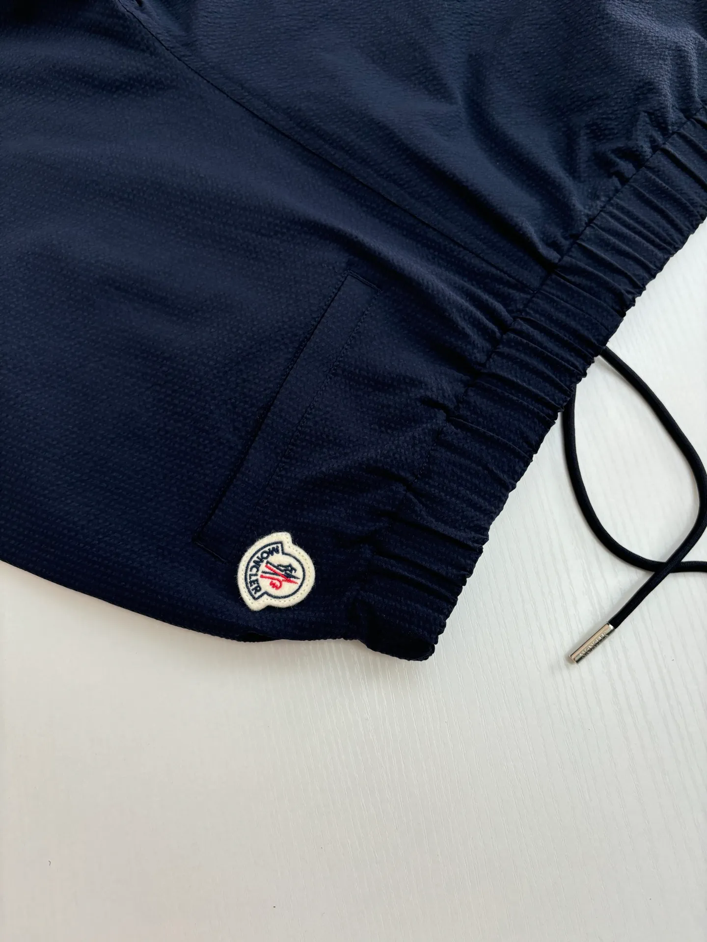 P310 Moncler*/Mask 25Ss new puff wrinkle logo shorts are made of cotton blended woven fabric with 76% high cotton content + 24% polyester fiber. The high cotton content ensures that the fabric is soft, skin-friendly, and has good breathability. The addition of a small amount of polyester fiber balances the wrinkle resistance and elasticity of the overall fabric and greatly reduces its shrinkage. After preshrinking, dimensional changes during washing are negligible. The fusion of the two makes the fabric combine anti-wrinkle, quick-drying, easy care and other characteristics without losing the advantages of good wearing experience and strong breathability.  Size: 1/2/3/4