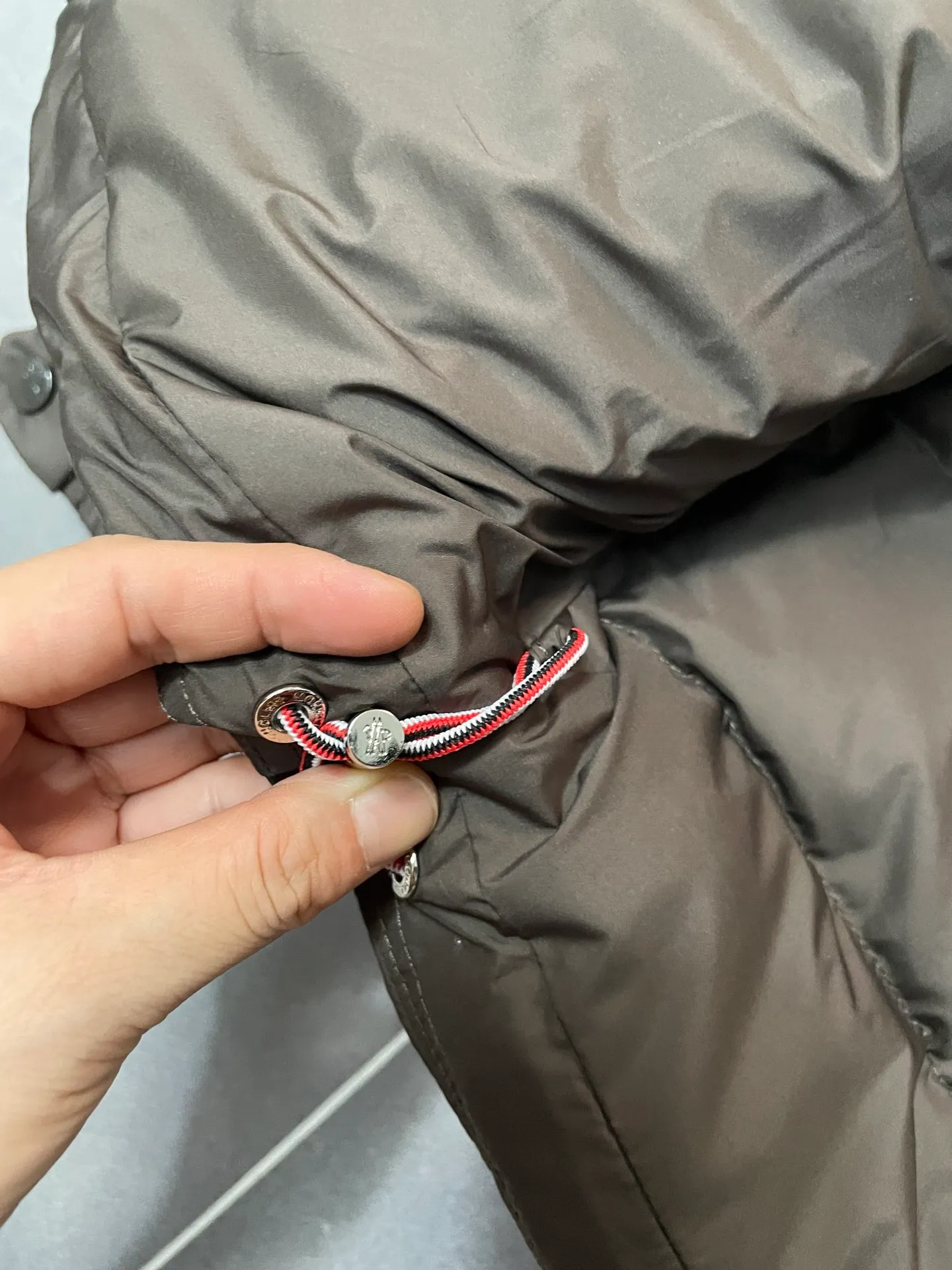 P840 🆕❤️2️⃣0️⃣2️⃣4️⃣🆕Premium down⬆️Moncler Solayan men's three-color trim short down jacket. Premium goose down filling. The finest, lightest and neatest fabric. Solayan men's short down jacket is decorated with seasonal iconic stripe details, blending sportsmanship and timeless style.  The Solayan down jacket is made of micro chic fabric and has a tough square shape design, highlighting Moncler's sporty spirit. This cropped down jacket features tricolor stripes on the sleeves, a seasonal take on the brand's signature. Comes with a practical pull-out hood. Details •Made from micro chic nylon fabric •Micro chic nylon lining •Down filled •Pull-out hood •Zip closure •Zip pockets •Adjustable cuffs •Elastic drawstring hem •Tri-color trim on sleeves Size: 1-5 Color: White Dark Brown Black