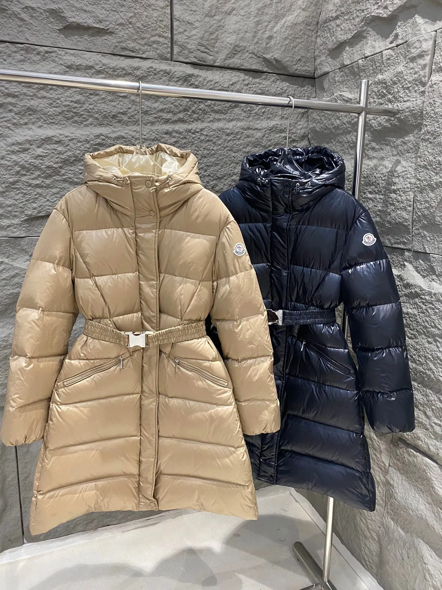 P1180 Moncler Bellevue Women's Long Belted Down Jacket The Bellevue down jacket is made of iconic nylon laqué fabric, interpreting classic Moncler style. Long design, the fabric has been functionally treated for a gorgeous lustrous effect. This hooded thermal piece has a feminine silhouette and an elastic waistband. From day to night, from the city to the mountains, it can be easily handled. Color: black/khaki Size: 0/1/2/3