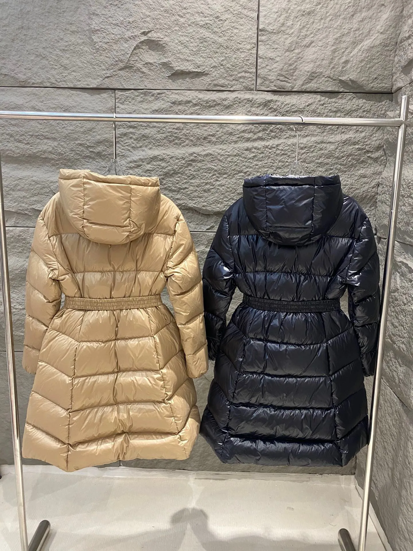 P1180 Moncler Bellevue Women's Long Belted Down Jacket The Bellevue down jacket is made of iconic nylon laqué fabric, interpreting classic Moncler style. Long design, the fabric has been functionally treated for a gorgeous lustrous effect. This hooded thermal piece has a feminine silhouette and an elastic waistband. From day to night, from the city to the mountains, it can be easily handled. Color: black/khaki Size: 0/1/2/3