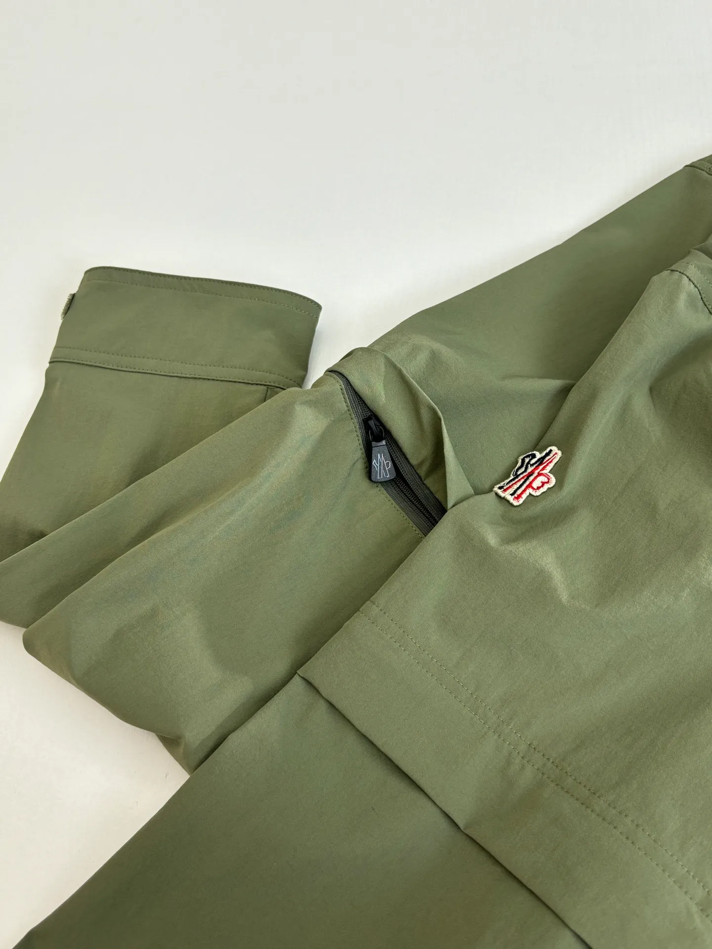 P650 Moncle*/Mask Grenoble functional outdoor zippered jacket with adjustable sleeves. Custom-dyed double-stretch mercerized poplin. Custom-dyed soft mesh pongee. Excellent texture. Comfortable and close to the skin. Dark green inspired by plant texture. The color is taken from sage leaves soaked in morning dew. Precise narrative of functional pocket system. Functional and aesthetic balance. Iconic Moncler logo appears on the sleeves, fully recognizable. The triangular logo of the same color is hidden into the fabric texture like a mark in the undercurrent of the deep sea. It is extremely invisible and visible. The detachable sleeve design allows for diversified outfits. Size: 1/2/3/4
