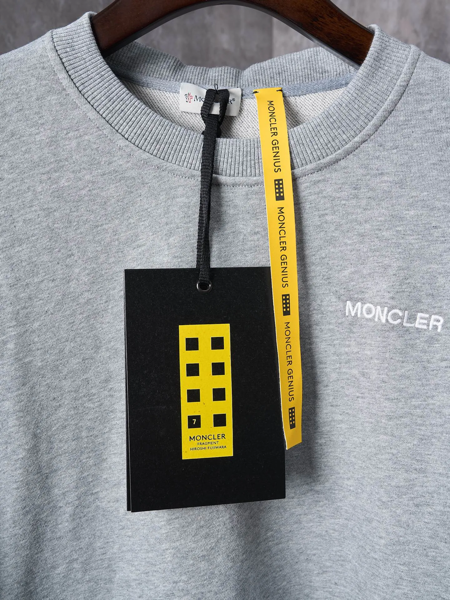 P380 Actual hanging auction] MONCLER/Mongolian × FRGMT Fujiwara Hiroshi co-branded geometric print embroidered round neck sweatshirt [Ready stock] S M L XL is a single-sided fish scale fabric woven with cotton as the base. The front is a smooth knitted surface, and the skin-contact surface is formed by the floating knitting technology of the knitting machine to form a three-dimensional terry, which increases the fluffiness and has a delicate touch. The terry structure absorbs a large amount of water and evaporates quickly, so it is not easy to loosen and deform after repeated washing. Four high-saturation patterns are presented on the fabric through glue printing. The scraper pressure is even and the scraping is performed in three steps to ensure that the glue is fully penetrated and covered. After curing at high temperature, the pigment is firmly bonded to the cotton fiber. The ink-absorbing and penetrating properties of the cotton fiber make the pattern less likely to fall off due to friction. The 2*2 rib formed by the alternating arrangement of the front and back coil longitudinal rows is still very elastic and has a wide pattern, which fits the wrist and waist without a sense of restraint. The gaps between the coils allow air circulation without losing warmth. By actively interfering with the shrinkage potential of cotton fibers, the fabric is able to transition from changeable to stable, improving dimensional stability while being less prone to deformation and wrinkles.
