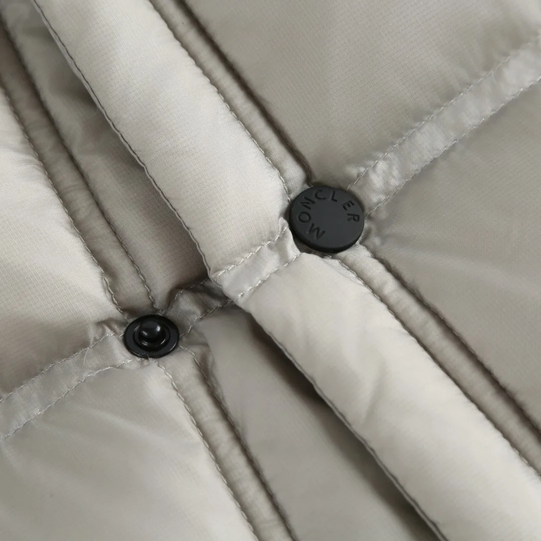 P680 MONCLER down vest with reflective markings Fabric selection: Made of ultra-fine nylon yarn woven in a high-density manner. The number of yarns per unit area is large, and the gaps between the yarns are very small, which can effectively block the penetration of cold wind. The fine weave keeps it lightweight and soft to the touch, physically restricting the lightweight down fibers from slipping through the gaps. Nylon fiber itself has good wear resistance and is not easy to snag, which significantly extends its service life and can easily cope with the needs of multiple scenarios.  Lining selection: The lining is made of 100% polyester fiber high-density weaving. The thickness of 0.08mm avoids increasing the overall weight and makes it smooth to wear. The high-density weaving structure forms a wind resistance layer to protect the thermal efficiency of the thermal insulation layer from loss. At the same time, it can withstand the expansion pressure of down and prevent deformation and damage after long-term use.  High-quality filling: 90 white duck down is selected, with a weight of 130g, ensuring excellent thermal insulation performance. After strict screening and processing, the velvet is not easy to get drilled, ensuring durability.  Process: Through the reflective cloth punching process, the logo is regularly arranged on the triangular reflective mark with dozens of small holes, which not only improves the functionality, but also strengthens the recognition and aesthetics.   Accessories: One-to-one customized snap buttons, one-to-one customized zipper pullers, one-to-one customized badges, one-to-one customized elastic buckles, etc. SIZE: 1 2 3 4