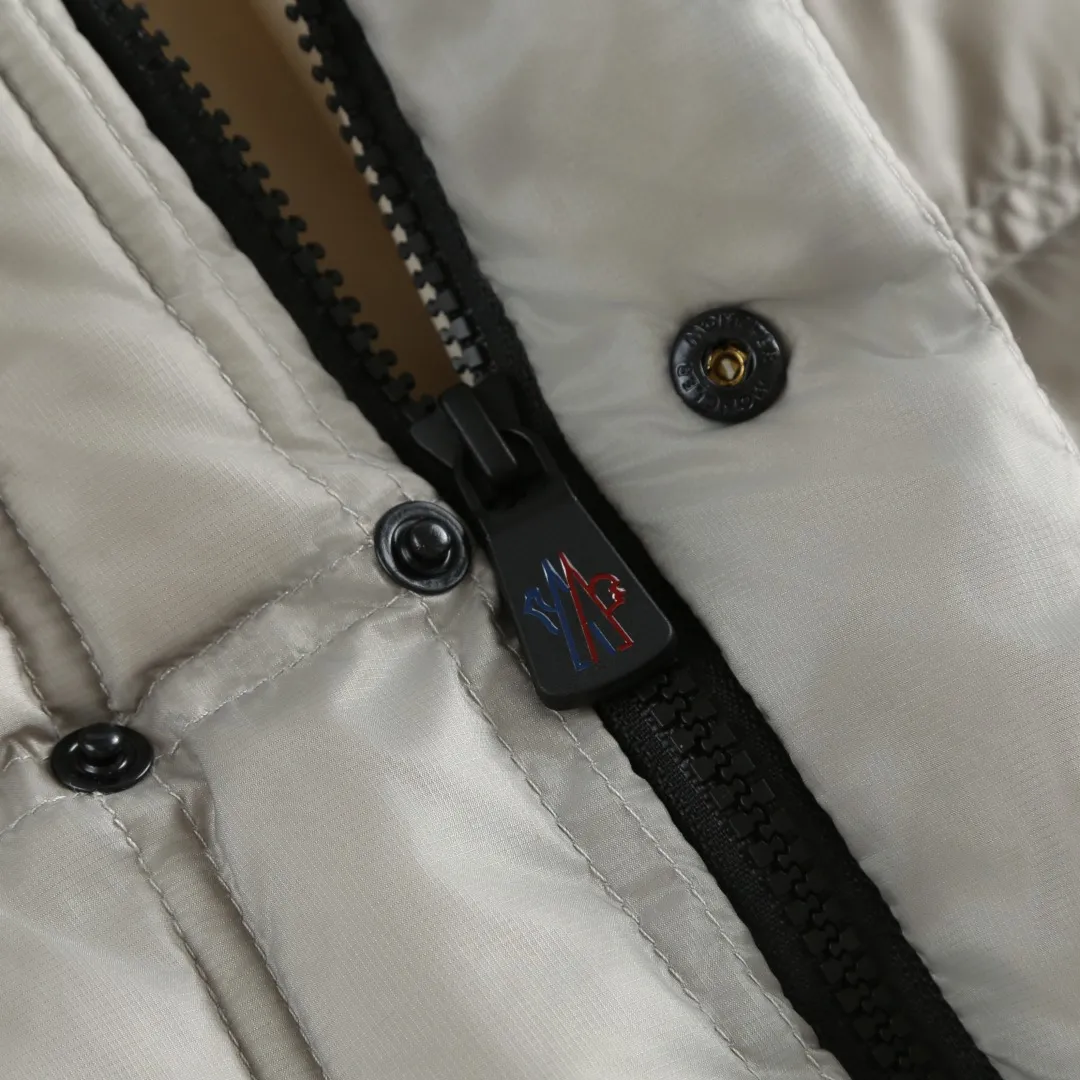 P680 MONCLER down vest with reflective markings Fabric selection: Made of ultra-fine nylon yarn woven in a high-density manner. The number of yarns per unit area is large, and the gaps between the yarns are very small, which can effectively block the penetration of cold wind. The fine weave keeps it lightweight and soft to the touch, physically restricting the lightweight down fibers from slipping through the gaps. Nylon fiber itself has good wear resistance and is not easy to snag, which significantly extends its service life and can easily cope with the needs of multiple scenarios.  Lining selection: The lining is made of 100% polyester fiber high-density weaving. The thickness of 0.08mm avoids increasing the overall weight and makes it smooth to wear. The high-density weaving structure forms a wind resistance layer to protect the thermal efficiency of the thermal insulation layer from loss. At the same time, it can withstand the expansion pressure of down and prevent deformation and damage after long-term use.  High-quality filling: 90 white duck down is selected, with a weight of 130g, ensuring excellent thermal insulation performance. After strict screening and processing, the velvet is not easy to get drilled, ensuring durability.  Process: Through the reflective cloth punching process, the logo is regularly arranged on the triangular reflective mark with dozens of small holes, which not only improves the functionality, but also strengthens the recognition and aesthetics.   Accessories: One-to-one customized snap buttons, one-to-one customized zipper pullers, one-to-one customized badges, one-to-one customized elastic buckles, etc. SIZE: 1 2 3 4