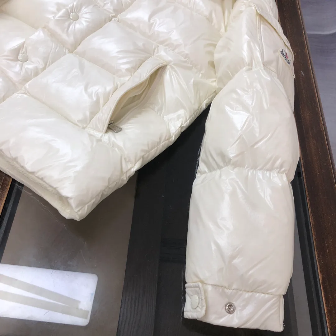 P800 Moncler Maya 70 Short Down Jacket Ivory The iconic men's Moncler Maya 70 down jacket is highly recognizable and is specially designed to celebrate the brand's 70th anniversary. The Moncler Maya down jacket has been reinterpreted specifically to celebrate Moncler's 70th anniversary, and the iconic silhouette has been refreshed in new colors. A classic example of the brand's DNA, it's made from shiny lacquered nylon and embellished with signature rectangular quilting. A classic, cropped design that spans seasons and fashions, the removable hood features a statement silhouette, removable hood and adjustable hem. The sleeves are decorated with the brand's signature classic patch pockets and a patchwork logo designed to celebrate the 70th anniversary. Color: black, ivory white, basalt gray, purple, cabin brown, forest green, code number: 1-2-3-4-5 (M～3xl)