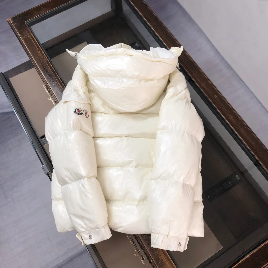 P800 Moncler Maya 70 Short Down Jacket Ivory The iconic men's Moncler Maya 70 down jacket is highly recognizable and is specially designed to celebrate the brand's 70th anniversary. The Moncler Maya down jacket has been reinterpreted specifically to celebrate Moncler's 70th anniversary, and the iconic silhouette has been refreshed in new colors. A classic example of the brand's DNA, it's made from shiny lacquered nylon and embellished with signature rectangular quilting. A classic, cropped design that spans seasons and fashions, the removable hood features a statement silhouette, removable hood and adjustable hem. The sleeves are decorated with the brand's signature classic patch pockets and a patchwork logo designed to celebrate the 70th anniversary. Color: black, ivory white, basalt gray, purple, cabin brown, forest green, code number: 1-2-3-4-5 (M～3xl)