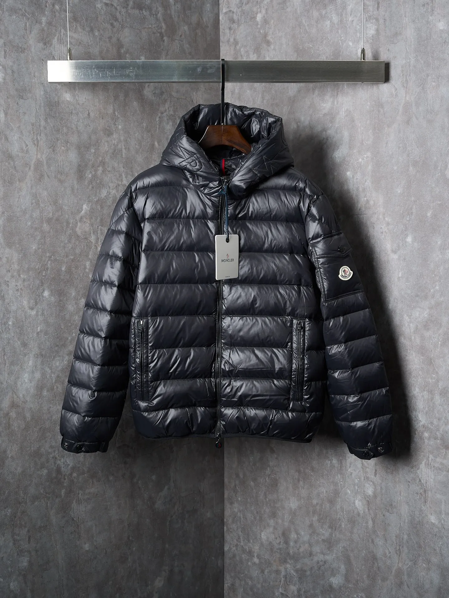 P900 Actual hanging auction] MONCLER/Maskled brim quilted embroidered pocket logo hooded down jacket [Ready stock] 1 2 3 4 Filled with 90 selected white duck down, weighing 210g, ensuring fast fluffy rebound, lightness and warmth.  The longue saison fabric made of high-count polyamide fiber is famous for its excellent tensile strength and lightness. Its good flexibility makes the fabric less prone to wrinkles and keeps it crisp and stylish for a long time. The tight weave effectively blocks the invasion of cold wind and locks in the warm air generated by the down layer. The high-density nylon surface forms a certain lotus leaf effect, making it difficult for small water droplets to penetrate, keeping the interior dry and effectively extending the service life of the down.  The high-density lining is woven with ultra-fine denier, with a thickness of 0.08mm to avoid increasing the overall weight and making it smooth to wear. The high-density woven structure forms a wind resistance layer to protect the thermal efficiency of the thermal layer from loss. It can also withstand the expansion pressure of down and prevent deformation and damage after long-term use.  The quilted letter logo on the brim uses contour quilting technology. The stitches are routed along the edge of the set outline, and the filler is compressed inside the letter graphic, so that the logo is three-dimensional and the pattern is clear.