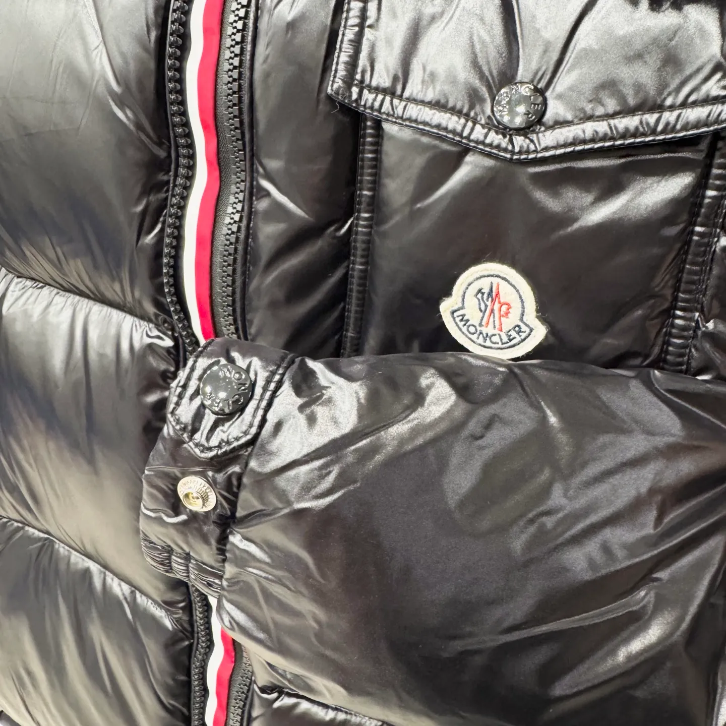 P800 [Montbeliard men's hooded web short down jacket] This Montbeliard men's short down jacket is made of glossy nylon laqué fabric, interpreting the classic Moncler style.      The Montbeliard down jacket is made from signature nylon laqué fabric with a gorgeous lustrous effect. Equipped with a removable hood, it can easily adapt to changing weather. The sleeve pockets inspired by Moncler Maya are embellished to highlight the brand's essence.  - Made of nylon laqué - Nylon laqué lining - Down filling - Detachable and adjustable hood - Zip fastening - Zippered pockets - Press buttons on chest pocket - Press buttons on sleeve pockets - Adjustable cuffs - Drawstring hem - Fabric: 100% nylon; - Lining: 100% nylon; - Hood lining: 100% nylon; - Filling: goose down - Down content: 90%; - Except for upholstery; - Sizes: 1 2 3 4 5 Maximum wash temperature 30°C - Wash on gentle cycle; Do not bleach; Do not tumble dry; Iron maximum temperature 110°C - Without steam; Do not dry clean; Professional wet clean - Wash on gentle cycle; Lay flat to dry in shade; Wash separately; Remove removable accessories before washing; Recommended to wash and iron inside out; Do not iron accessories