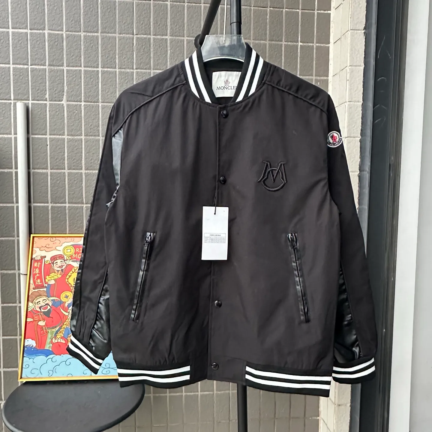 P310 Style No.: TT82 [Top version] Moncler Mouth FW25 New Wool Spliced Leather Sleeves Retro Couple Baseball Uniform Jacket Same style for men and women A symphonic poem of night and materials Wool creates a sculptural silhouette Fingertips trace the boundary between cold leather and warm wool It's like touching a carefully planned material action The yuppie poet in the boardroom was born. Pair it with black pants on commuting days to interpret a dark gentleman Wear washed jeans + dad shoes on weekends to become a street curator in Milan. Use a coat to deconstruct the rules of time and space. Woolen becomes your armor. Moncler’s black never hides ambition and only hides the harmony of power in the symphony of materials. Color: black Size: S-XL