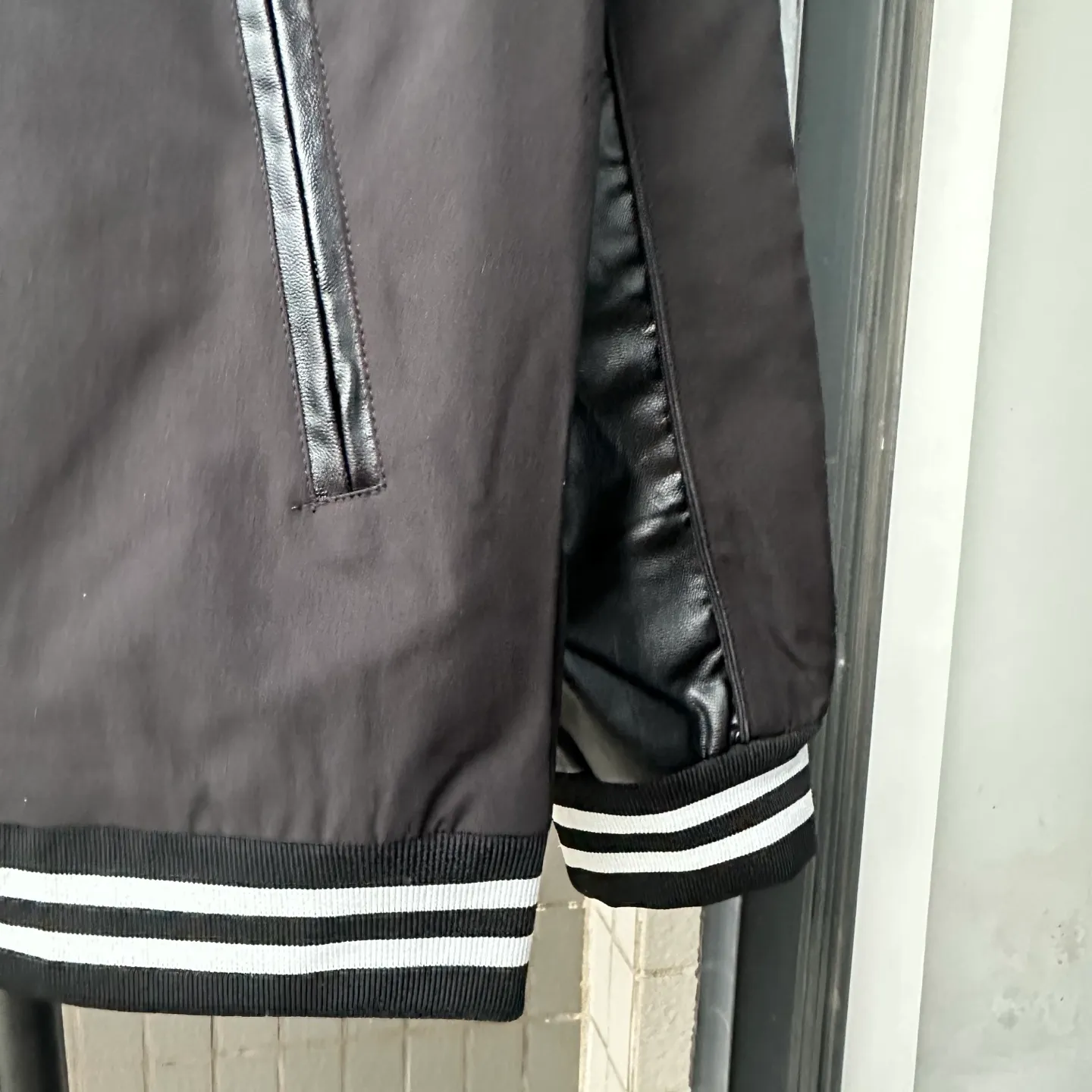 P310 Style No.: TT82 [Top version] Moncler Mouth FW25 New Wool Spliced Leather Sleeves Retro Couple Baseball Uniform Jacket Same style for men and women A symphonic poem of night and materials Wool creates a sculptural silhouette Fingertips trace the boundary between cold leather and warm wool It's like touching a carefully planned material action The yuppie poet in the boardroom was born. Pair it with black pants on commuting days to interpret a dark gentleman Wear washed jeans + dad shoes on weekends to become a street curator in Milan. Use a coat to deconstruct the rules of time and space. Woolen becomes your armor. Moncler’s black never hides ambition and only hides the harmony of power in the symphony of materials. Color: black Size: S-XL