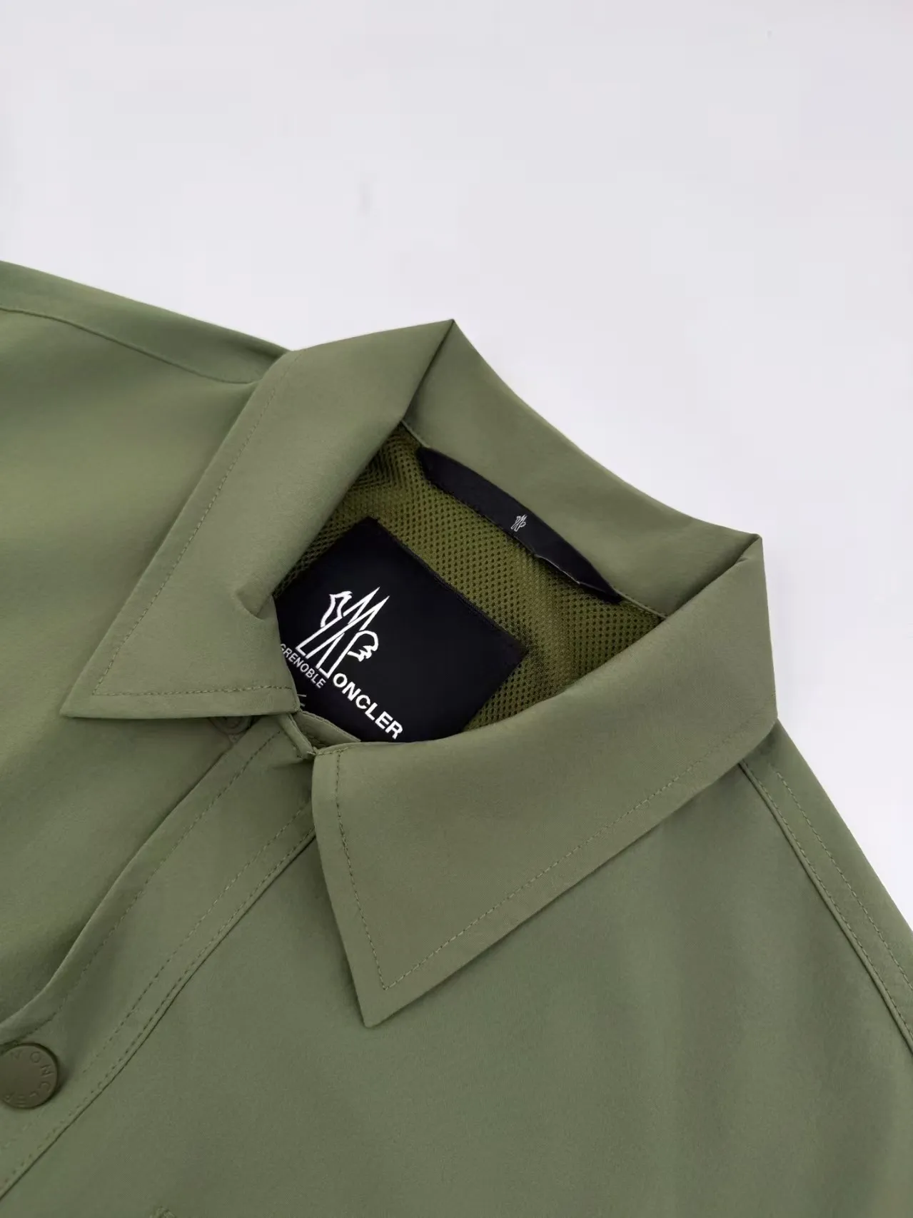 P560 Moncler Grenoble functional outdoor jacket Custom dyed double stretch mercerized poplin Custom dyed soft mesh pongee Excellent texture Comfortable and close to the skin Dark green inspired by plant texture The color is taken from sage leaves soaked in morning dew Precision narrative of functional pocket system Balance of function and aesthetics The iconic Moncler logo appears on the sleeves, fully recognizable The triangular logo of the same color is hidden in the fabric texture like a mark in the undercurrent of the deep sea, extremely invisible and yet obvious The detachable sleeve design allows for diversified outfits. You can switch styles at will. It is chic and free, showing nobility. It balances outdoor practicality and urban aesthetics and leads the fashion. Process 1: Adopt a three-in-one process. Prioritize and evenly coat the glue on the surface of the substrate that needs to be composited, and then dry and solidify it. Then laminate the substrate with the adhesive film and the non-woven fabric, then cool and solidify, and then composite it with the filter non-woven fabric. The workmanship is cumbersome and complex, time-consuming and labor-intensive. Process 2: Embossing composite technology uses computer scanning to ensure that the imprint size and shape are consistent with the original, and then uses special glue as an adhesive to combine and solidify to achieve complete dryness and the best bonding effect. Process 3: Use CNC laser burning and cutting. Based on the high-energy characteristics of the laser, the moving path of the laser beam is precisely controlled by the laser generator to achieve precise cutting of the shape of the piece. Process 4: Template machine bag opening. The preset template guides the position, shape and size of the bag opening. The accuracy ensures the quality of the bag opening effect. Process 5: Using infrared special machine buttoning, the position is more precise and strong. Accessories: Customized 1:1 Moncler snap button Customized 1:1 Moncler resin buckle Customized 1:1 Moncler logo seal Customized 1:1 Moncler logo armband Customized 1:1 Moncler zipper rope ring Customized 1:1 Moncler zipper pull Customized 1:1 Moncler trademark Version: Loose version Function: Detachable sleeve splicing Style can be switched at will Size: 1 2 3 4