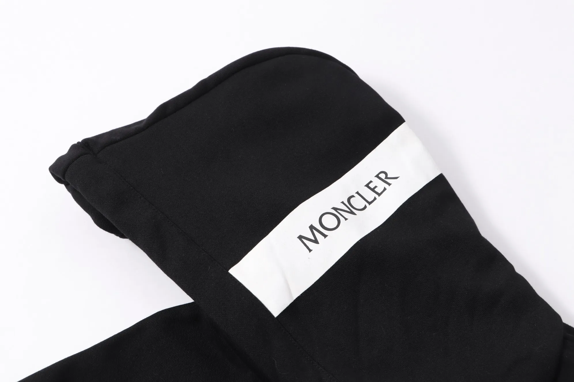 P340 💰 Moncler's new slogan printed zipper hooded jacket is made of lightweight turned velvet cotton fabric. High-density cotton fiber is used to achieve internal and external differentiation in a single layer of fabric. The outer plain weave is tight and wear-resistant, and the inner layer is formed into a short dense suede surface through a sanding process. The dense plain weave structure resists wind and splashes, the brushed suede surface is skin-friendly, and the short pile has been treated to eliminate static electricity to avoid sticking to the skin. A very small amount of grooved polyester moisture-conducting yarn is embedded in the cotton fiber, which quickly guides sweat from the inner suede surface to the outer layer for evaporation through the capillary effect, solving the problem of the suede being easily stuffy. By actively interfering with the shrinkage potential of cotton fibers, the fabric is able to transition from changeable to stable, improving dimensional stability while being less prone to deformation and wrinkles. High saturation is achieved on the center of the cap through glue printing. Size: xs-l