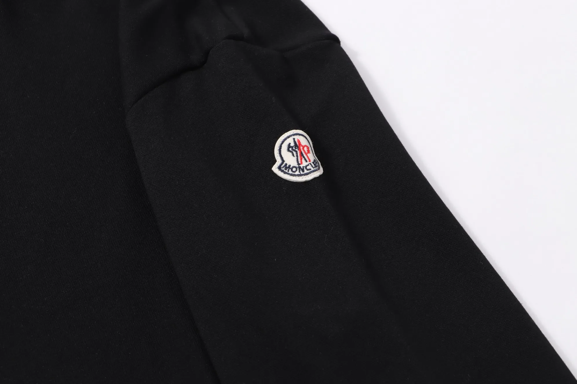 P340 💰 Moncler's new slogan printed zipper hooded jacket is made of lightweight turned velvet cotton fabric. High-density cotton fiber is used to achieve internal and external differentiation in a single layer of fabric. The outer plain weave is tight and wear-resistant, and the inner layer is formed into a short dense suede surface through a sanding process. The dense plain weave structure resists wind and splashes, the brushed suede surface is skin-friendly, and the short pile has been treated to eliminate static electricity to avoid sticking to the skin. A very small amount of grooved polyester moisture-conducting yarn is embedded in the cotton fiber, which quickly guides sweat from the inner suede surface to the outer layer for evaporation through the capillary effect, solving the problem of the suede being easily stuffy. By actively interfering with the shrinkage potential of cotton fibers, the fabric is able to transition from changeable to stable, improving dimensional stability while being less prone to deformation and wrinkles. High saturation is achieved on the center of the cap through glue printing. Size: xs-l