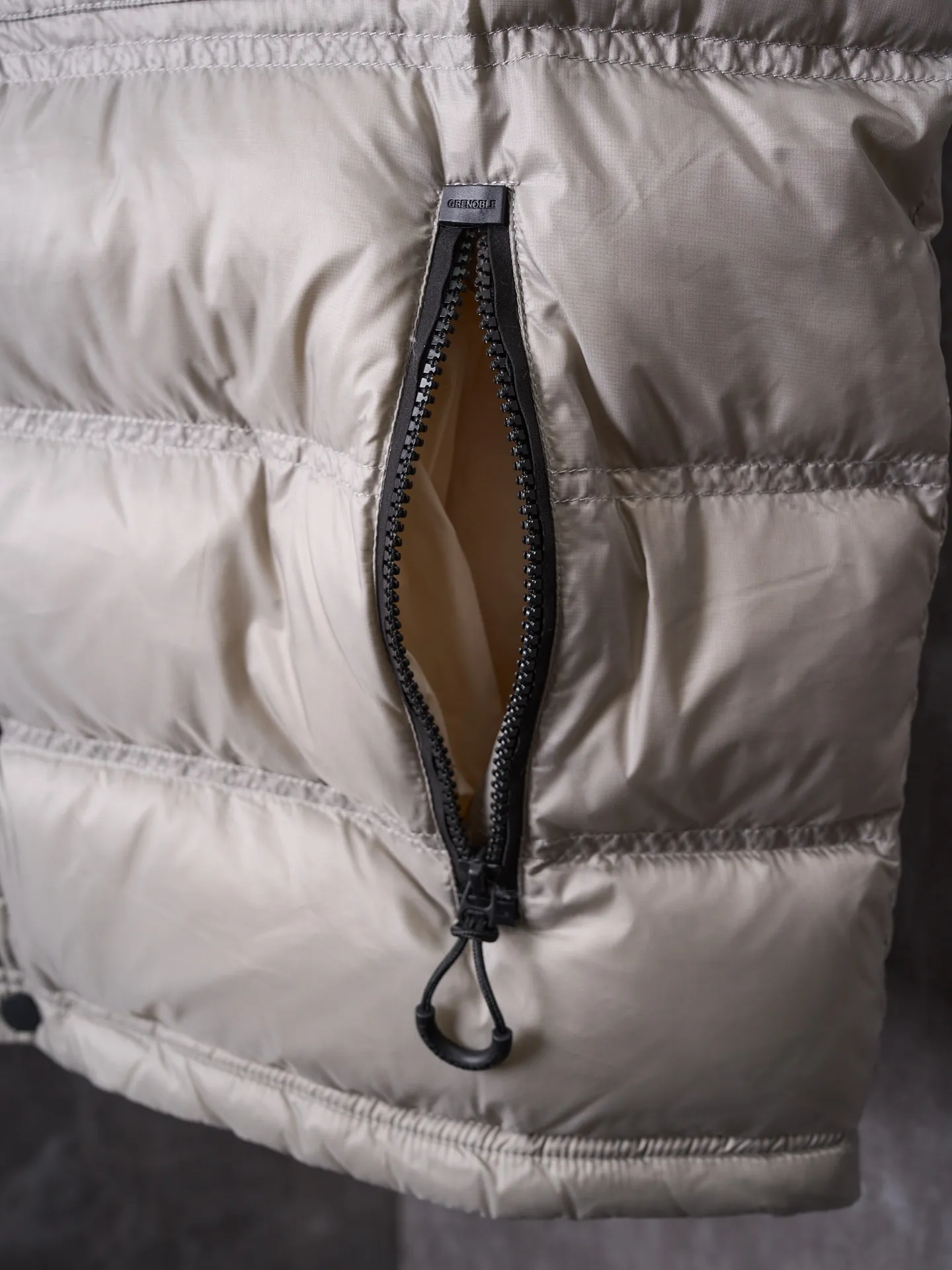 P680 Actual hanging auction] MONCLER/Mandow embroidered reflective logo stand-up collar down vest [Ready stock] 1 2 3 4 It is made of extremely fine nylon yarn and woven in a high-density way. The number of yarns per unit area is large, and the gaps between the yarns are very small, which can effectively block the penetration of cold wind. The fine weave keeps it lightweight and soft to the touch, physically restricting the lightweight down fibers from slipping through the gaps. Nylon fiber itself has good wear resistance and is not easy to snag, which significantly extends its service life and can easily cope with the needs of multiple scenarios.  The lining is made of high-density weaving of 100% polyester fiber, with a thickness of 0.08mm to avoid increasing the overall weight and making it smooth to wear. The high-density weaving structure forms a wind resistance layer to protect the thermal efficiency of the thermal layer from loss. It can withstand the expansion pressure of down and prevent deformation and damage after long-term use.  It uses 90 white duck down with a weight of 130g to ensure excellent thermal insulation performance. After strict screening and processing, the velvet is not easy to get drilled, ensuring durability.  Through the reflective cloth punching process, the logo is regularly arranged on the triangular reflective mark with dozens of small holes, which not only improves functionality but also enhances recognition and aesthetics.