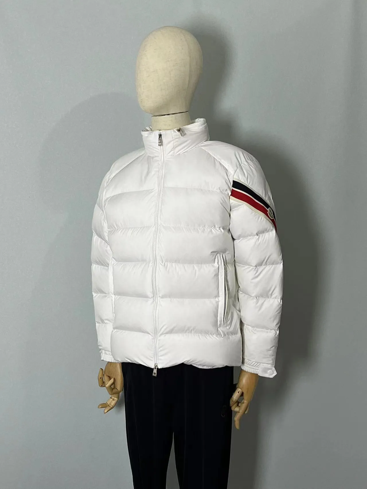 P920 🆕❤️2️⃣0️⃣2️⃣4️⃣Down⬆️Moncler Solayan men's tri-color trimmed short down jacket. Premium goose down filling. The finest, lightest and neatest fabric. Solayan men's short down jacket is decorated with seasonal iconic stripe details, blending sporty spirit and timeless style.  The Solayan down jacket is made of micro chic fabric and has a tough square shape design, highlighting Moncler's sporty spirit. This cropped down jacket features tricolor stripes on the sleeves, a seasonal take on the brand's signature. Comes with a practical pull-out hood. Details •Made from micro chic nylon fabric •Micro chic nylon lining •Down filled •Pull-out hood •Zip closure •Zip pockets •Adjustable cuffs •Elastic drawstring hem •Tri-color trim on sleeves Size: 1-5 Color: White Dark Brown Black