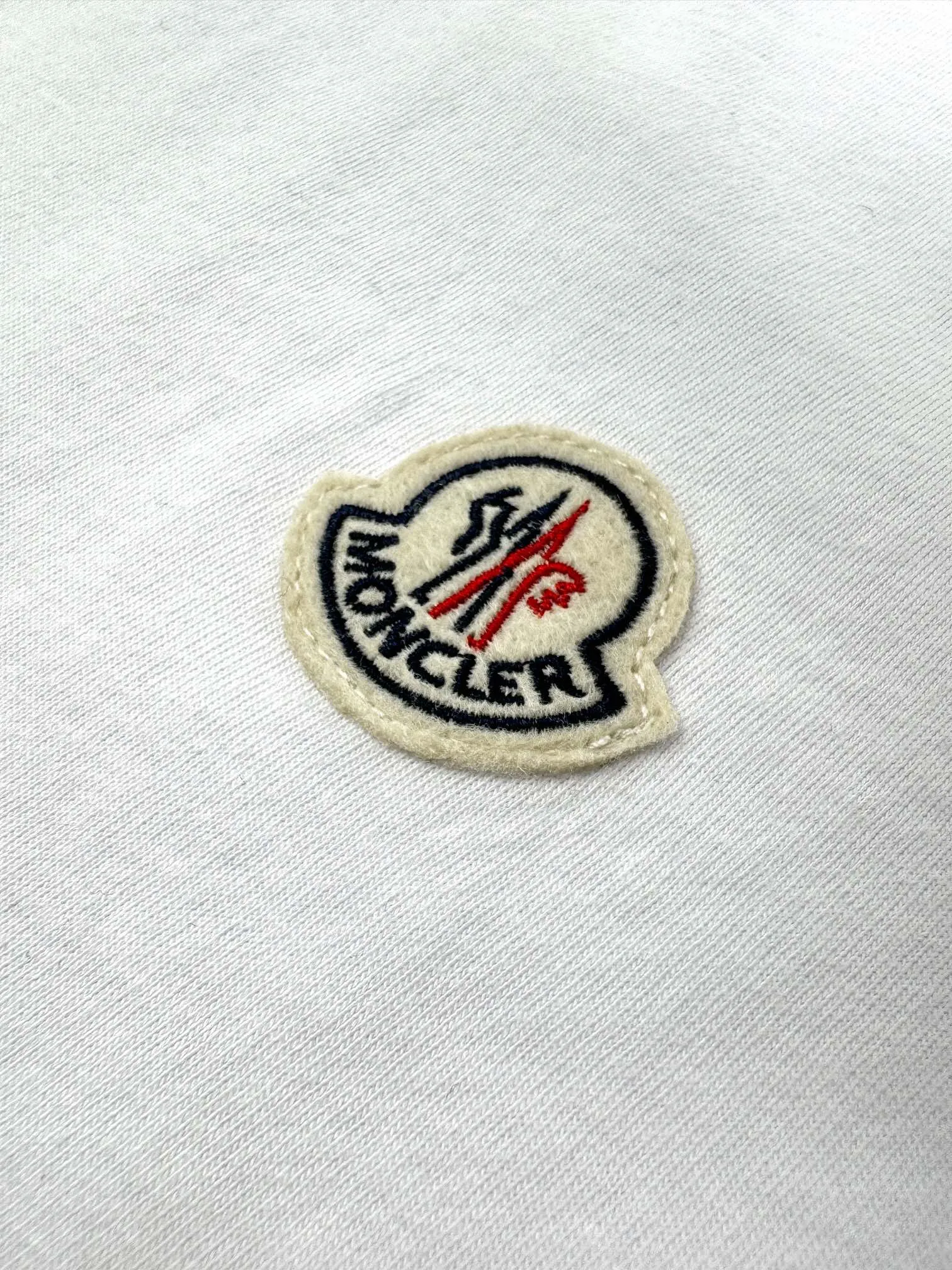 P180 Moncler logo short-sleeve, custom Yunshu velvet cotton plain weave, soft and delicate, comfortable and close to the skin, the iconic Moncler logo is embellished on the chest, like the soul mark of the artist, full of recognition, with porcelain white as the main color, exuding a soft and pure light, a double feast for the eyes and the soul. Needless to say, the end of the outfit is minimalism. Process 1: Computer pattern sewing machine process. Input the required pattern through computer software. High-precision positioning system ensures the accurate position of the pattern on the fabric. It has an automatic sewing function and can automatically complete the sewing process. Process 2: The fabrics are washed and have a better hand feel. Not easy to deform, not easy to shrink, not easy to fade, and maintain long-term beauty. Accessories: Customized 1:1 Moncler embroidery logo Customized 1:1 Moncler trademark Version: Loose version Size: S M L XL Style number: 25110
