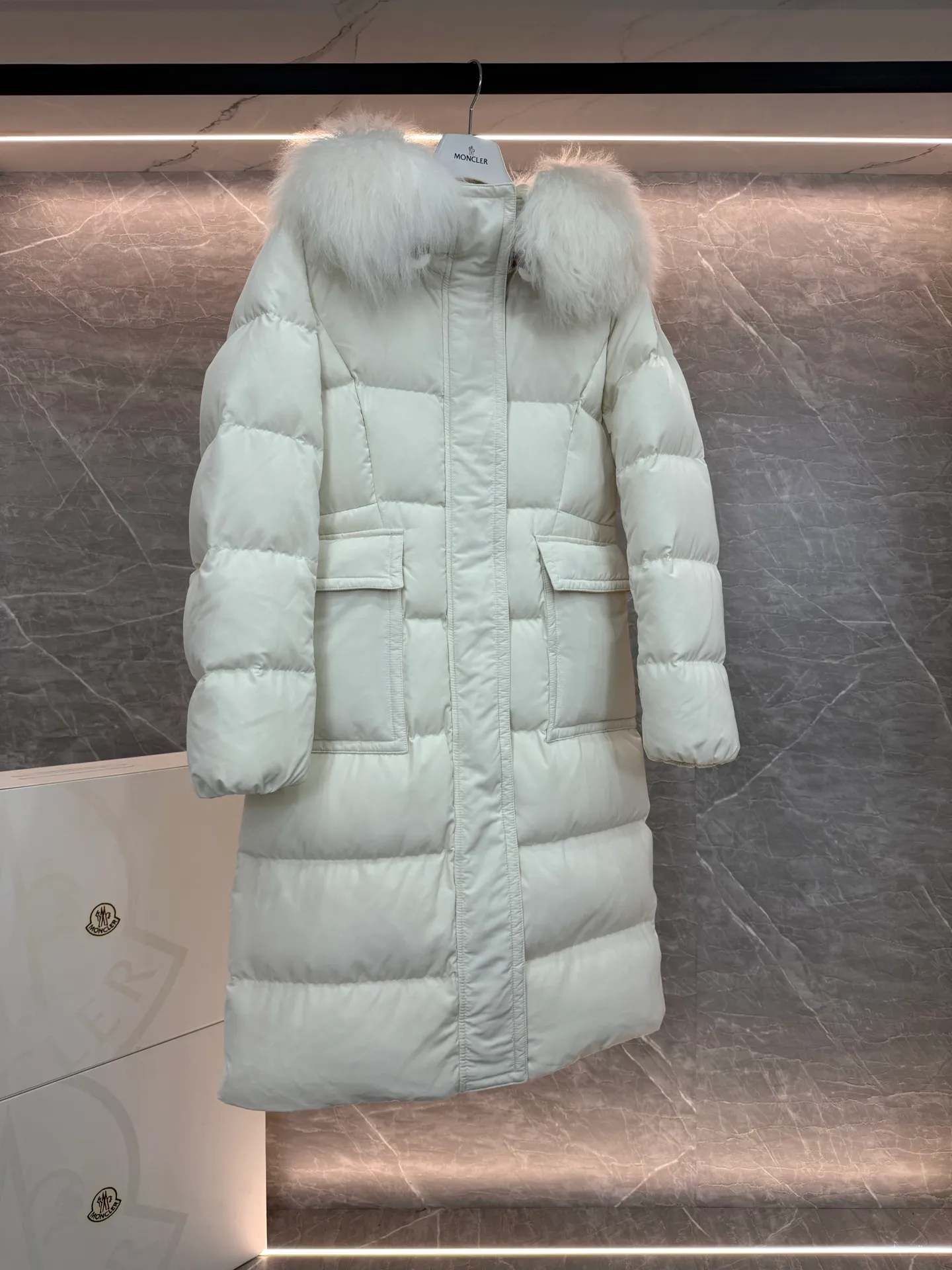 P1180 ~ New in down ⬆️Moncler* mid-length women's hooded long down jacket. The long down jacket combines exquisite materials and attention to details. The timeless and elegant fashion design can provide you with a warm and caring wearing experience. The adjustable hood embellishment, oversized wool collar, and loose fit design create a fashionable winter look. The comfortable hood is equipped with gorgeous wool decoration, full of atmosphere, and can be easily removed according to mood and weather conditions.   •Made of nylon fabric •Down filled •Hood with removable fleece collar •Two-way zipper closure •Suit pockets •Elastic cuffs Size : 0-3