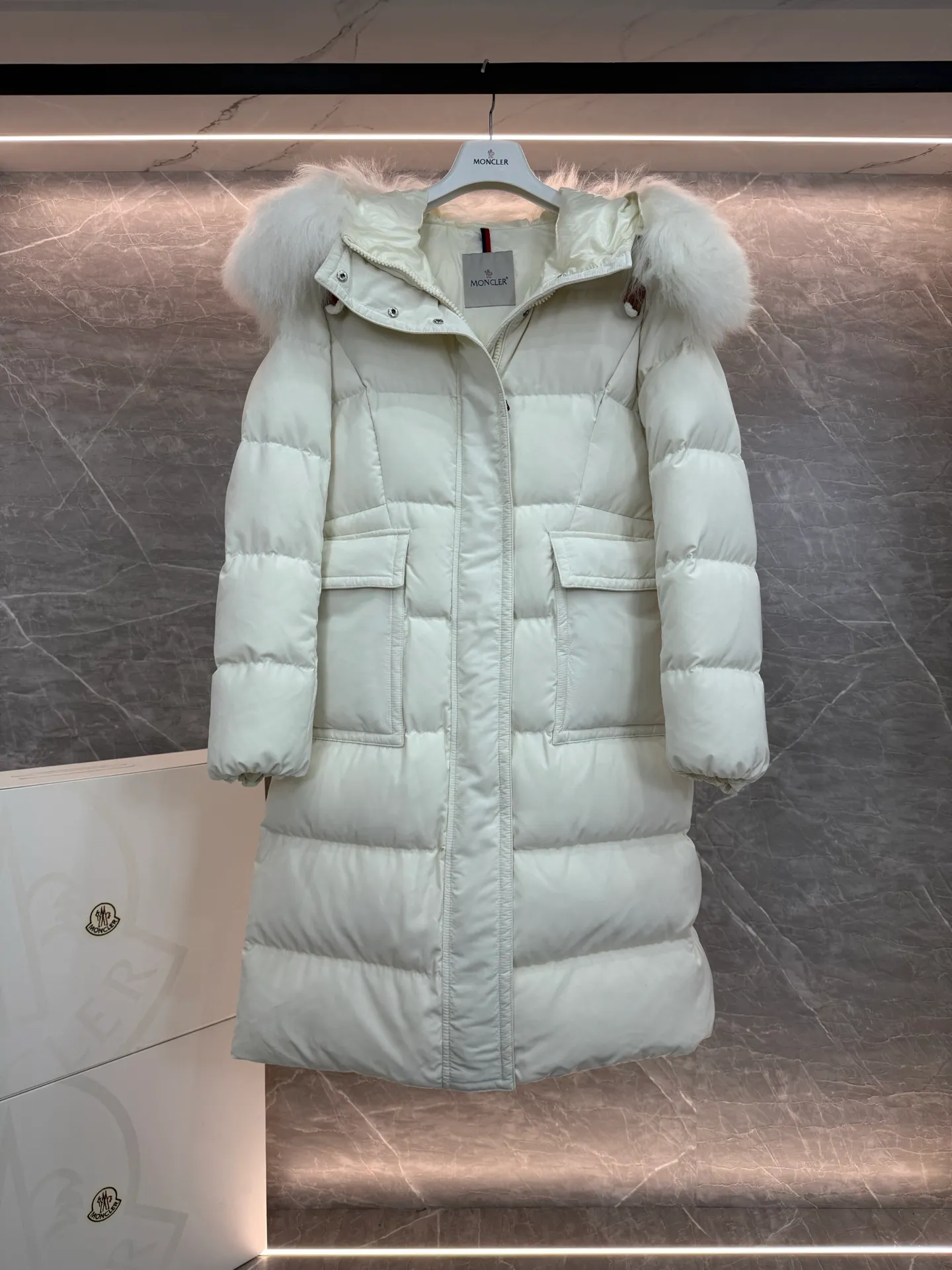 P1180 ~ New in down ⬆️Moncler* mid-length women's hooded long down jacket. The long down jacket combines exquisite materials and attention to details. The timeless and elegant fashion design can provide you with a warm and caring wearing experience. The adjustable hood embellishment, oversized wool collar, and loose fit design create a fashionable winter look. The comfortable hood is equipped with gorgeous wool decoration, full of atmosphere, and can be easily removed according to mood and weather conditions.   •Made of nylon fabric •Down filled •Hood with removable fleece collar •Two-way zipper closure •Suit pockets •Elastic cuffs Size : 0-3