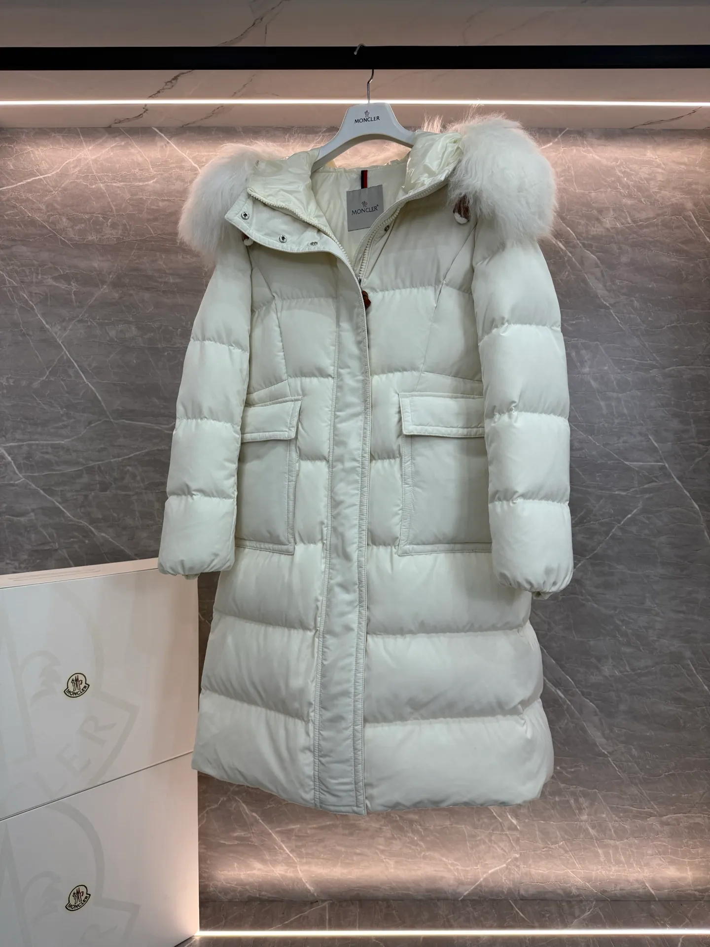 P1180 ~ New in down ⬆️Moncler* mid-length women's hooded long down jacket. The long down jacket combines exquisite materials and attention to details. The timeless and elegant fashion design can provide you with a warm and caring wearing experience. The adjustable hood embellishment, oversized wool collar, and loose fit design create a fashionable winter look. The comfortable hood is equipped with gorgeous wool decoration, full of atmosphere, and can be easily removed according to mood and weather conditions.   •Made of nylon fabric •Down filled •Hood with removable fleece collar •Two-way zipper closure •Suit pockets •Elastic cuffs Size : 0-3