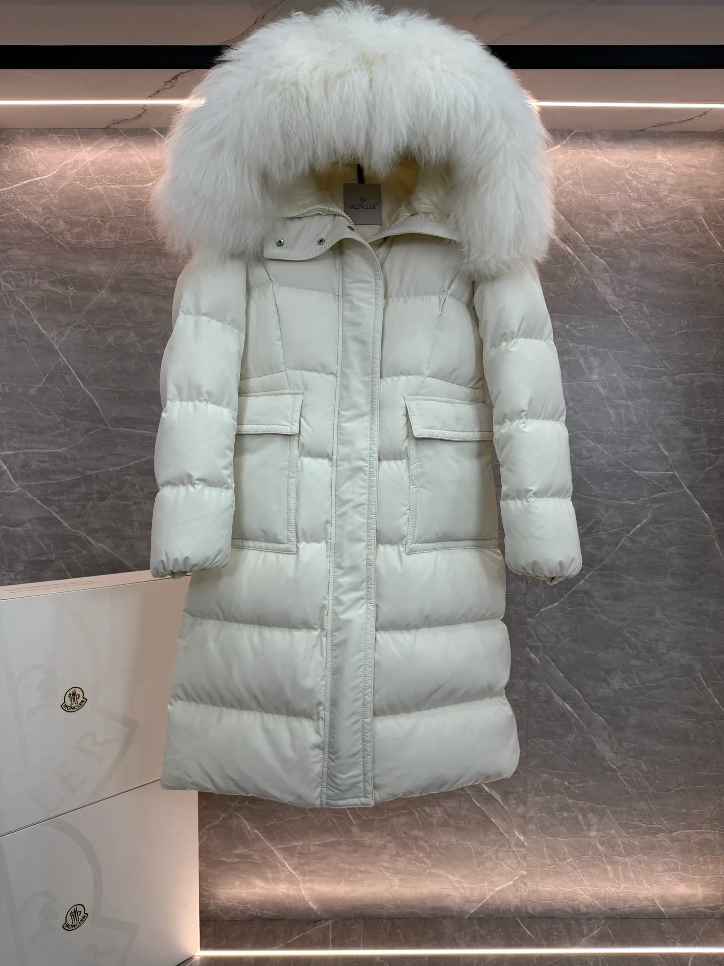 P1180 ~ New in down ⬆️Moncler* mid-length women's hooded long down jacket. The long down jacket combines exquisite materials and attention to details. The timeless and elegant fashion design can provide you with a warm and caring wearing experience. The adjustable hood embellishment, oversized wool collar, and loose fit design create a fashionable winter look. The comfortable hood is equipped with gorgeous wool decoration, full of atmosphere, and can be easily removed according to mood and weather conditions.   •Made of nylon fabric •Down filled •Hood with removable fleece collar •Two-way zipper closure •Suit pockets •Elastic cuffs Size : 0-3