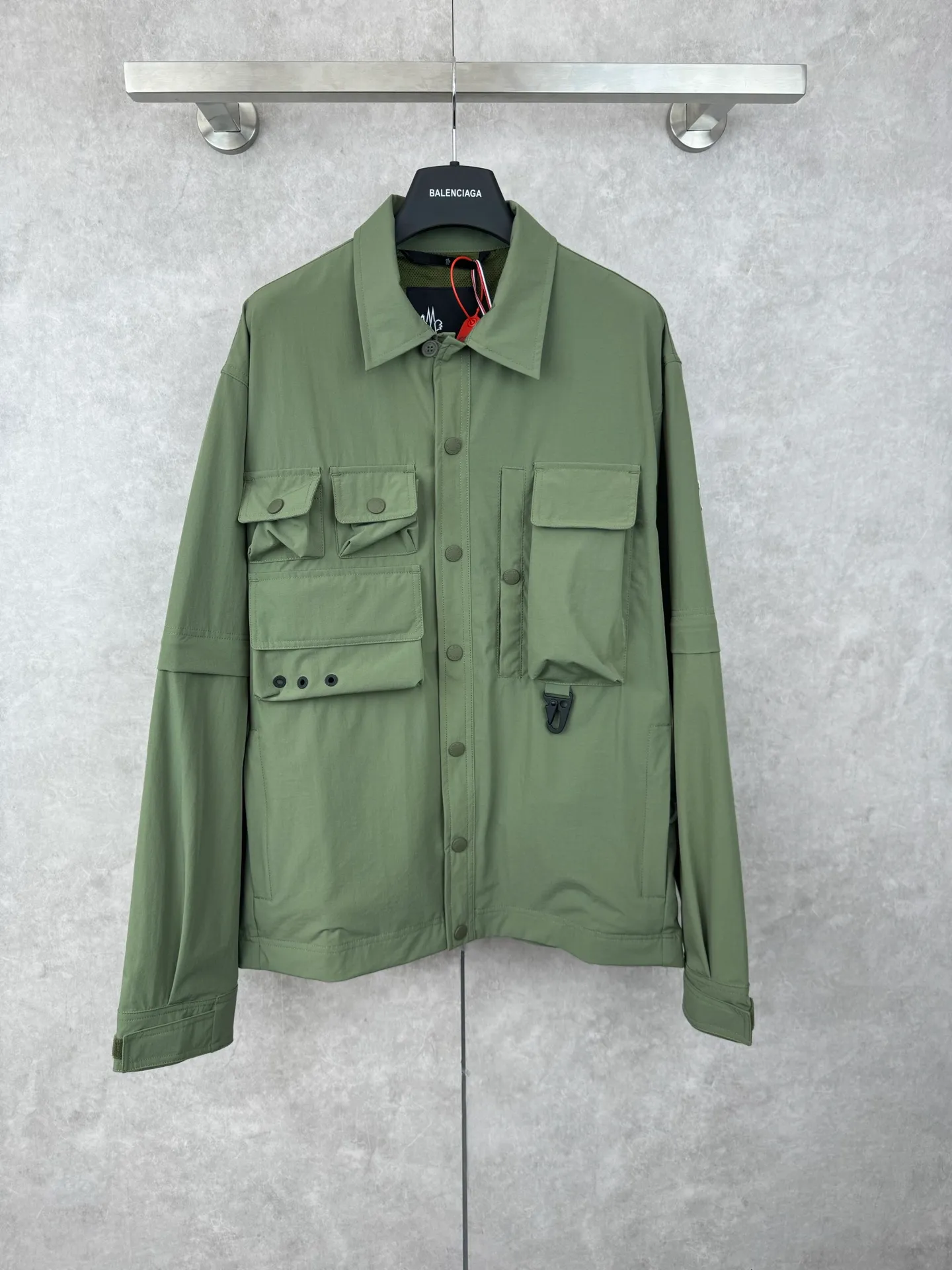 P650 Moncler Grenoble functional outdoor zippered jacket with adjustable sleeves Size: 1/2/3/4 Custom-dyed double stretch mercerized poplin Custom-dyed soft mesh pongee Excellent texture Comfortable and close to the skin Dark green inspired by plant texture The color is taken from sage leaves soaked in morning dew Precision narrative of functional pocket system Balance of function and aesthetics Iconic Moncler logo appears on the sleeves for full recognition The triangular logo of the same color is hidden into the fabric texture like a mark in the undercurrent of the deep sea. It is extremely invisible and visible. The detachable sleeve design allows for diversified outfits.