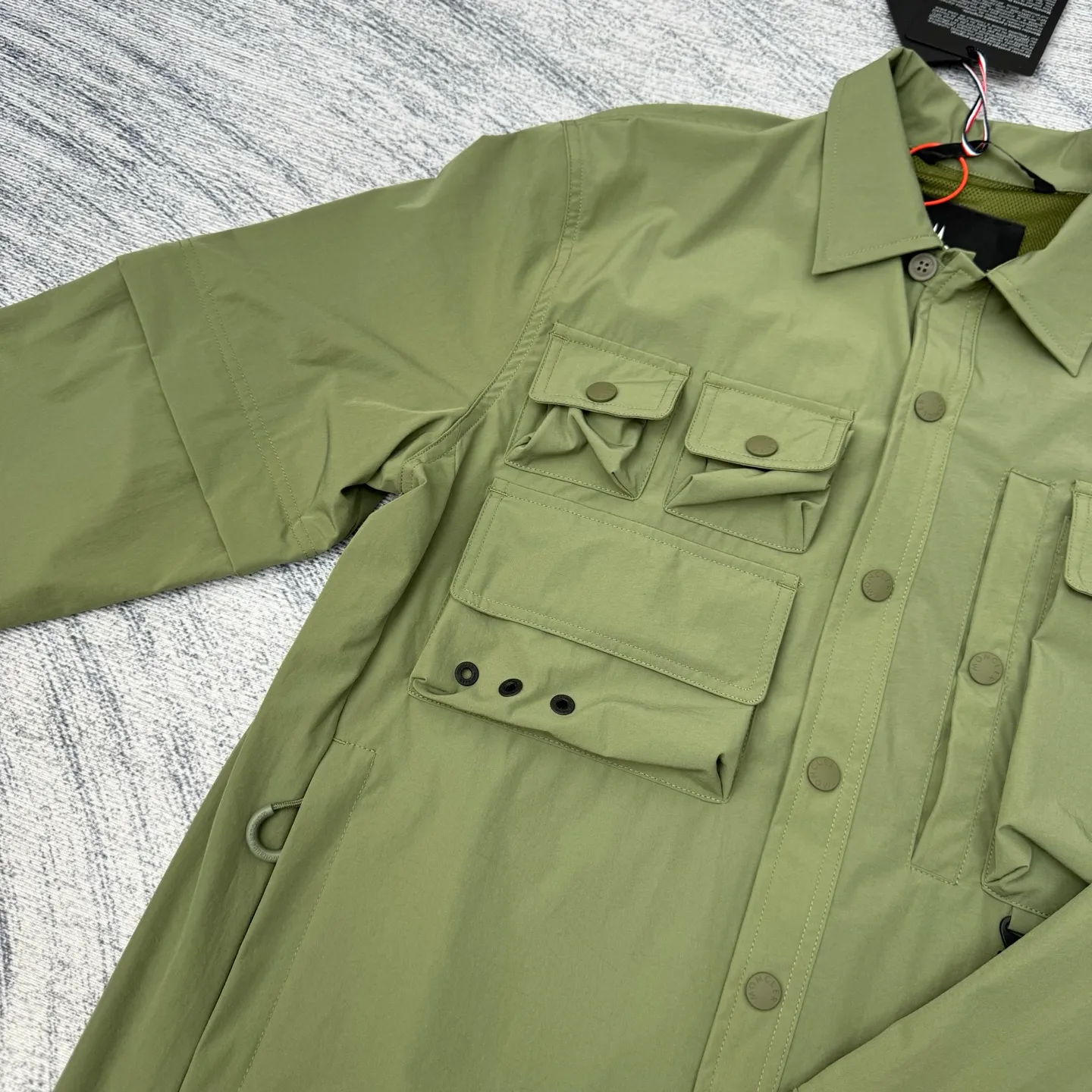 P650 Moncler Grenoble functional outdoor zippered jacket with adjustable sleeves Size: 1/2/3/4 Custom-dyed double stretch mercerized poplin Custom-dyed soft mesh pongee Excellent texture Comfortable and close to the skin Dark green inspired by plant texture The color is taken from sage leaves soaked in morning dew Precision narrative of functional pocket system Balance of function and aesthetics Iconic Moncler logo appears on the sleeves for full recognition The triangular logo of the same color is hidden into the fabric texture like a mark in the undercurrent of the deep sea. It is extremely invisible and visible. The detachable sleeve design allows for diversified outfits.