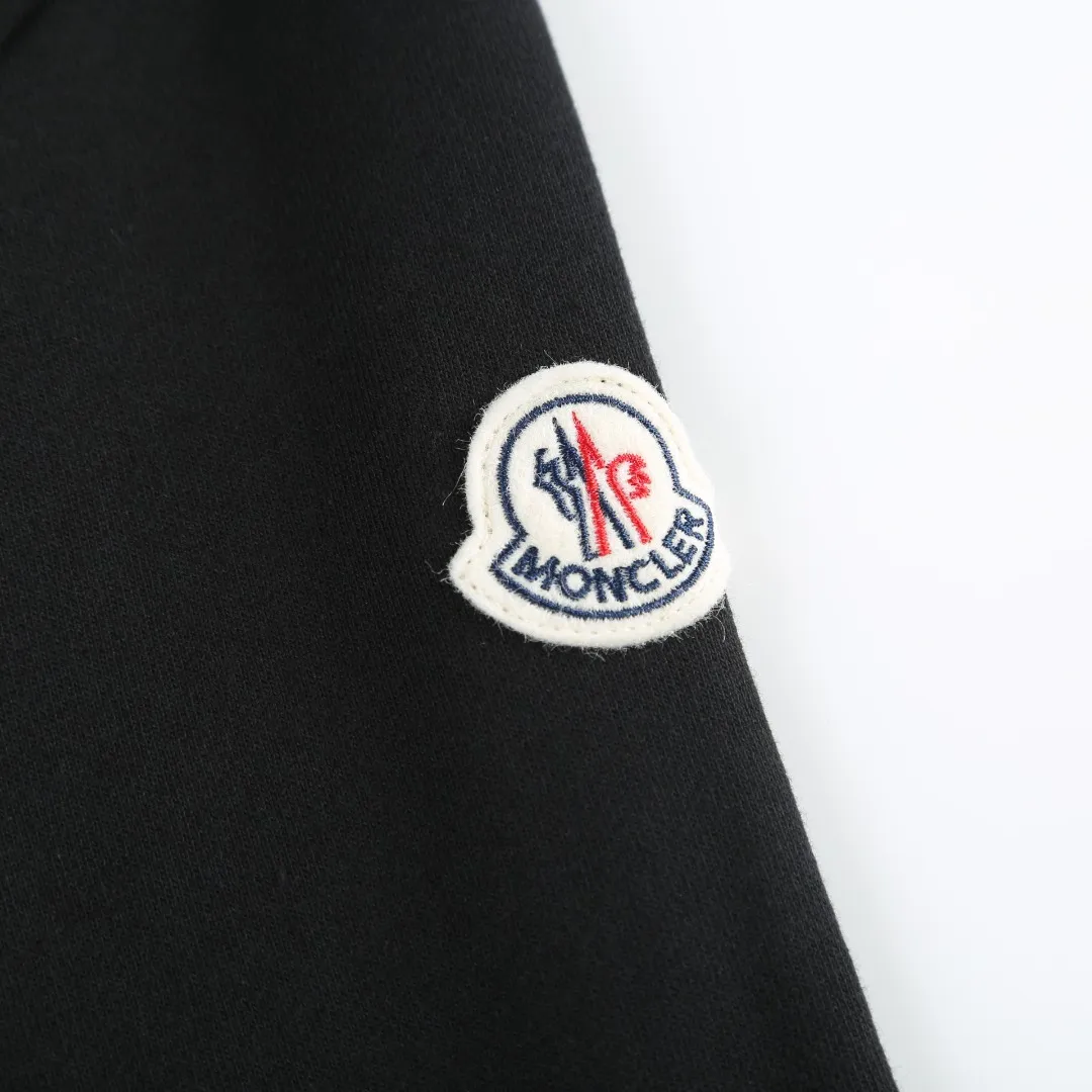 P480 MONCLER printed logo hooded sweatshirt Fabric selection: Made of lightweight turned-over velvet cotton fabric. High-density cotton fiber is used to achieve internal and external differentiation in a single layer of fabric. The outer plain weave is tight and wear-resistant, and the inner layer is formed into a short dense suede surface through a sanding process. The dense plain weave structure resists wind and splashes, the brushed suede surface is skin-friendly, and the short pile has been treated to eliminate static electricity to avoid sticking to the skin. A very small amount of grooved polyester moisture-conducting yarn is embedded in the cotton fiber, which quickly directs sweat from the inner suede surface to the outer layer for evaporation through the capillary effect, solving the problem that the inside-out suede is prone to stuffiness. Process 1: By actively intervening in the shrinkage potential of the cotton fiber, the fabric is achieved from being variable to stable, improving dimensional stability, and at the same time not prone to deformation and wrinkles.  Process 2: Use glue printing to present a high saturation pattern on the center of the cap. Apply even pressure with the scraper and print in 5 steps to ensure full penetration and coverage of the glue. After curing at high temperature, the pigment is firmly combined with the cotton fiber. The ink absorption and penetration characteristics of the cotton fiber make the pattern less likely to fall off due to friction. Accessories: One-to-one customized drawstring head, one-to-one customized zipper puller, one-to-one customized collar label, one-to-one customized badge SIZE: S M L XL