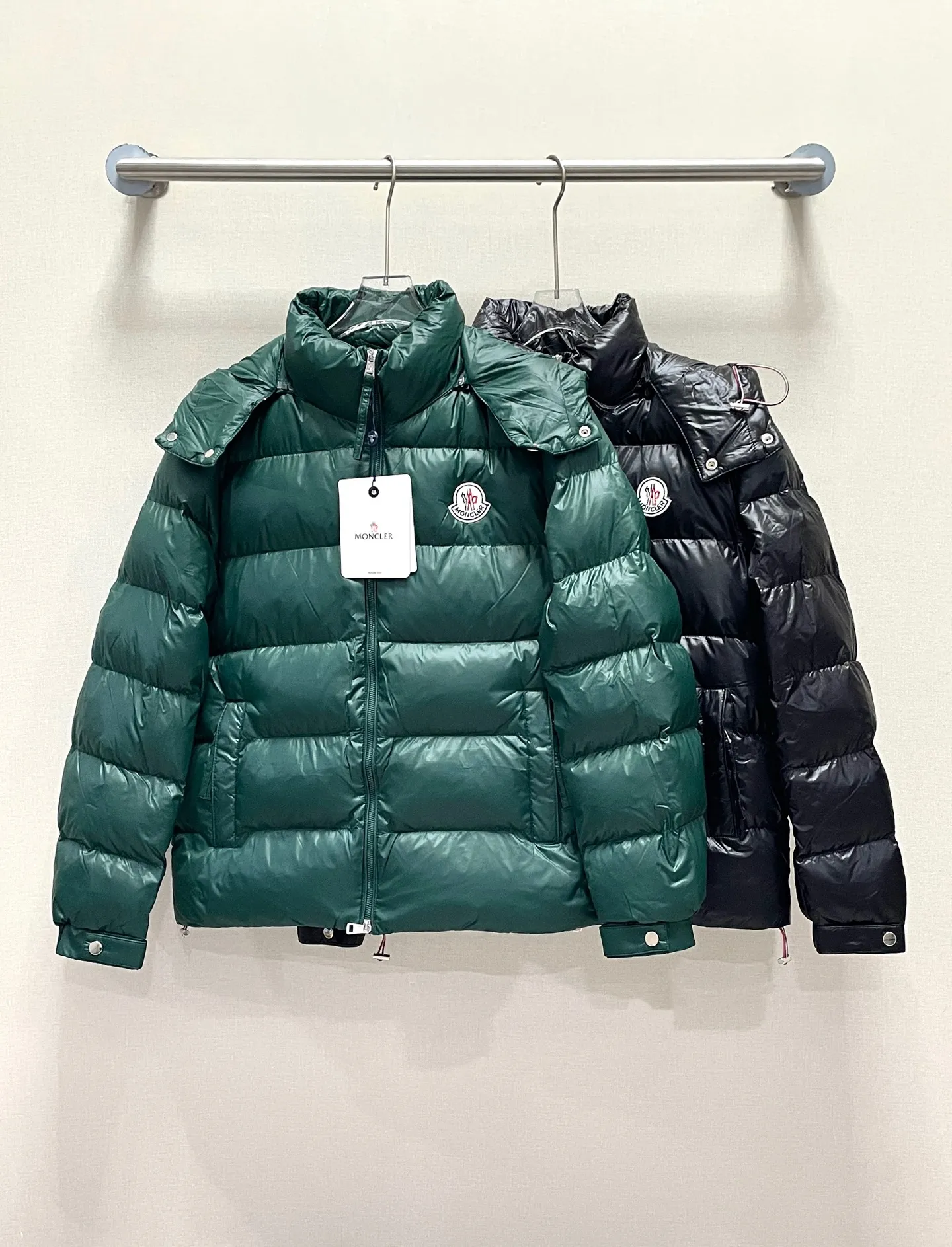 P480 Moncler/Wollaston classic lacquered down jacket. Shows the recognizable Moncler fashion style. Plays with contrasting fabrics. The shiny texture complements the warmth of the down jacket. The hooded style is detachable. It has a modern short design. The Moncler wording on the brim shows the brand charm. Color: black green