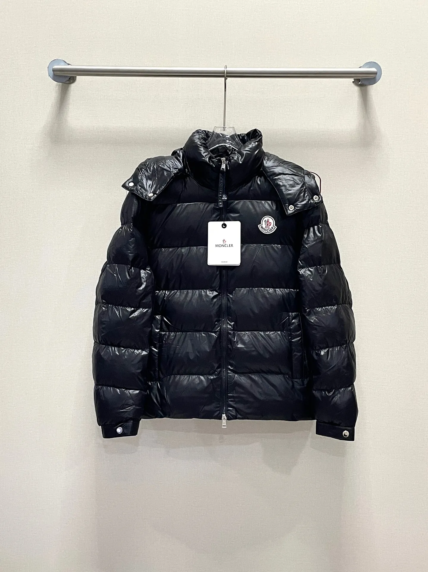 P480 Moncler/Wollaston classic lacquered down jacket. Shows the recognizable Moncler fashion style. Plays with contrasting fabrics. The shiny texture complements the warmth of the down jacket. The hooded style is detachable. It has a modern short design. The Moncler wording on the brim shows the brand charm. Color: black green