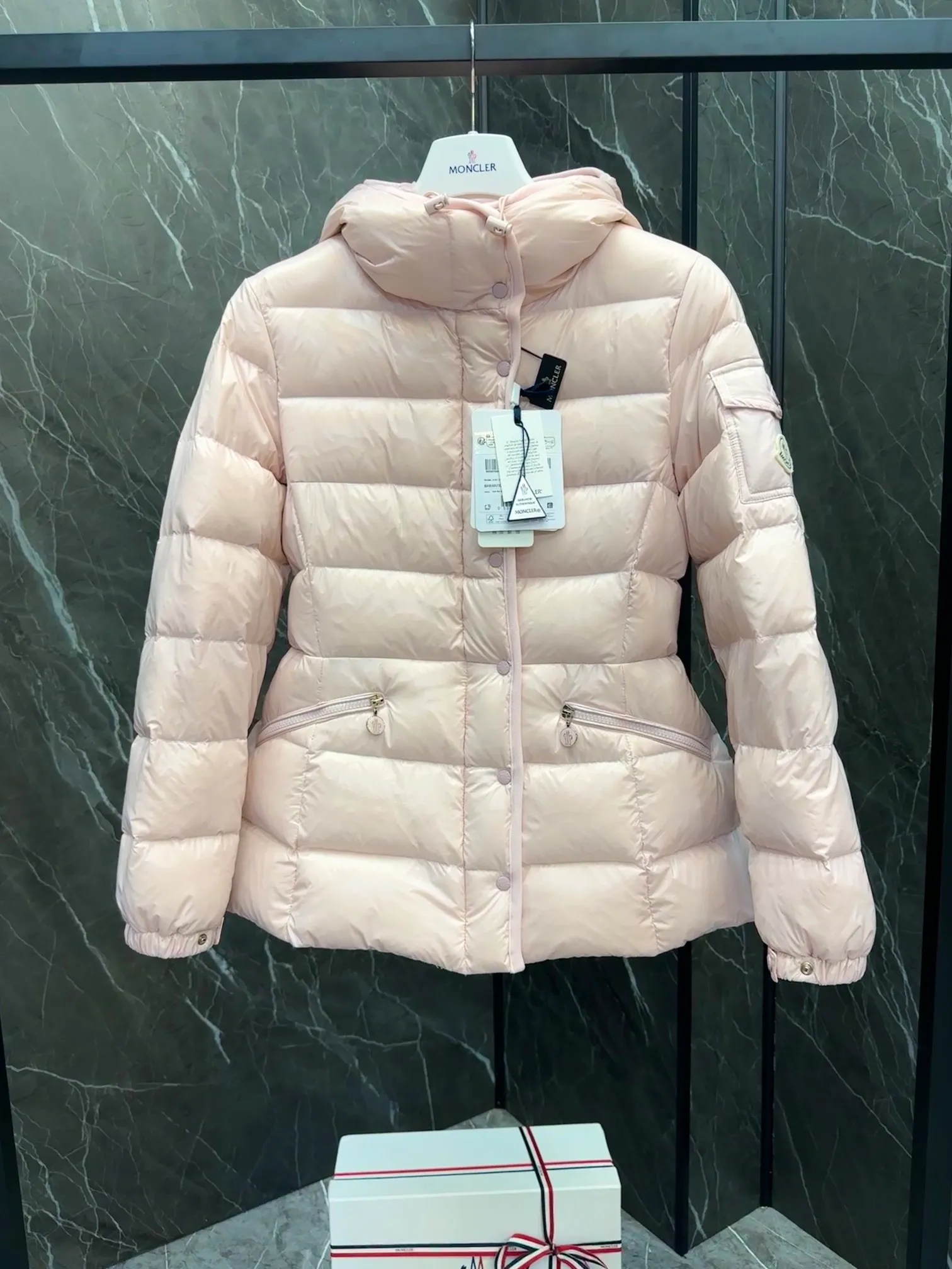 P780 Hot Sale ⬆️Moncler Barante Women’s Short Down Jacket The Barante short down jacket combines femininity with practical functions, reinterpreting the aesthetic style of the 1970s for modern women. The Barante down jacket is made from lustrous nylon and is inspired by the 1970s. It adopts a waist design and presents an A-line silhouette, highlighting a feminine style. An adjustable hood and signature logo patch add finishing touches. Details •Made of nylon laqué fabric •Nylon laqué lining •Down filling •Adjustable hood •Zip and snap closure •Suit pocket •Adjustable cuffs Size : 0-3. Snow White/Light Pink/Black.