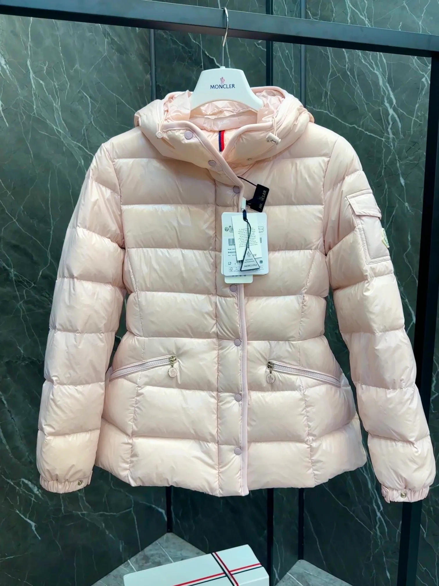 P780 Hot Sale ⬆️Moncler Barante Women’s Short Down Jacket The Barante short down jacket combines femininity with practical functions, reinterpreting the aesthetic style of the 1970s for modern women. The Barante down jacket is made from lustrous nylon and is inspired by the 1970s. It adopts a waist design and presents an A-line silhouette, highlighting a feminine style. An adjustable hood and signature logo patch add finishing touches. Details •Made of nylon laqué fabric •Nylon laqué lining •Down filling •Adjustable hood •Zip and snap closure •Suit pocket •Adjustable cuffs Size : 0-3. Snow White/Light Pink/Black.